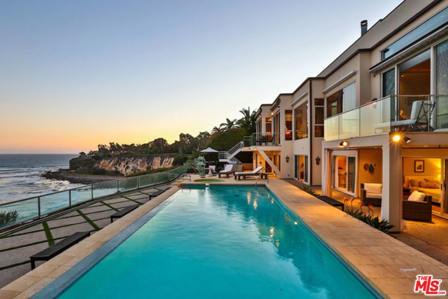 Palace on the beach. Spectacular gated architectural estate on Point Dume. Long private driveway, floor to ceiling glass, and ocean views grace all rooms. A bridge and waterfall lead you to a stately entry. Dramatic living room with high ceilings, wood details, and marble floors. Formal dining room is surrounded with etched glass panels. Gracious master suite with his and her baths. Four additional en-suite bedrooms, library/media room, lighted north/south tennis court, and bluff top ocean view pool make this home fit for a king. Truly extraordinary property built to the highest standards that must be seen to be believed.