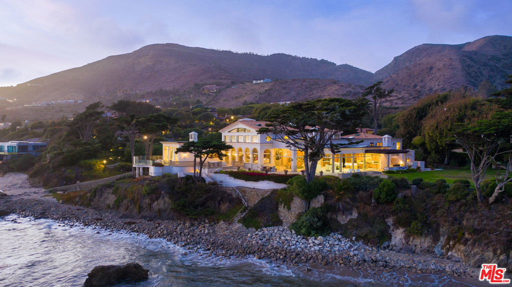 Once in a lifetime a property comes on the market that transcends the epitome of Malibu living. For the first time ever this Malibu Oceanfront Landmark Estate has become available. Enter through your private gates to this Magnificent Villa on 281 ft +/- of ocean frontage. 10 lots totaling approximately 1.56 acres. The Private Villa encompasses 10,500 sq ft of luxury living on 3 levels. Massive high ceilings throughout all the main entertaining spaces with walls of glass to gaze out to the whitewater and sunset vistas yet at the same time affording complete privacy from the beach below. Master Suite with whitewater and sunset views down the coastline. The oceanfront massive wrap around terrace is completely private from public eye and has a private staircase to the beach and sand below. Other amenities include 3 upstairs ocean view bedroom suites with a large guest terrace, basement includes wine cellar, game room, space for a home theatre, gym and direct access to the beach for your morning jog.