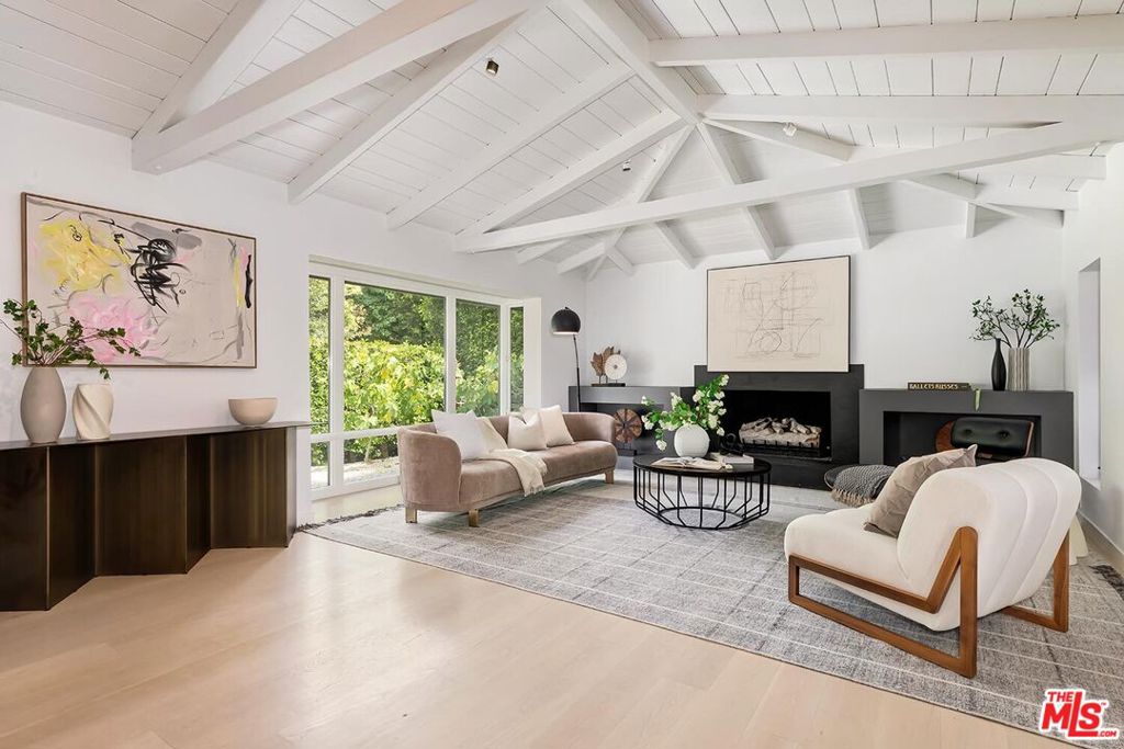 Elegant California Bungalow with Exceptional Design and Versatility. This beautifully updated California Bungalow combines classic charm with modern sophistication. Light-filled and airy, the home features dramatic vaulted, beamed ceilings, three fireplaces, and stunning oak flooring throughout. The main residence includes 2 spacious bedrooms and 3 bathrooms, complemented by two attached guest suites each with their own private bath offering a total of 4 bedrooms and 5 bathrooms. The expansive primary suite includes a cozy sitting area, creating a serene retreat. A chef's dream kitchen boasts Sub-Zero and Viking appliances, Caesarstone countertops, custom cabinetry, a generous center island with refrigerated beverage drawers, and a built-in banquette. Adjacent to the kitchen, the media room/den with vaulted ceilings provides a perfect space for relaxation or entertaining. With a unique and flexible layout, the guest suites are ideal for use as home offices, creative studios, a gym, or private quarters for visitors. The property is fully walled and gated, ensuring complete privacy and security. Nestled near scenic Franklin Canyon Park, with its duck pond and hiking trails, this home offers an exceptional lifestyle in a tranquil yet convenient setting. Truly beautiful living.