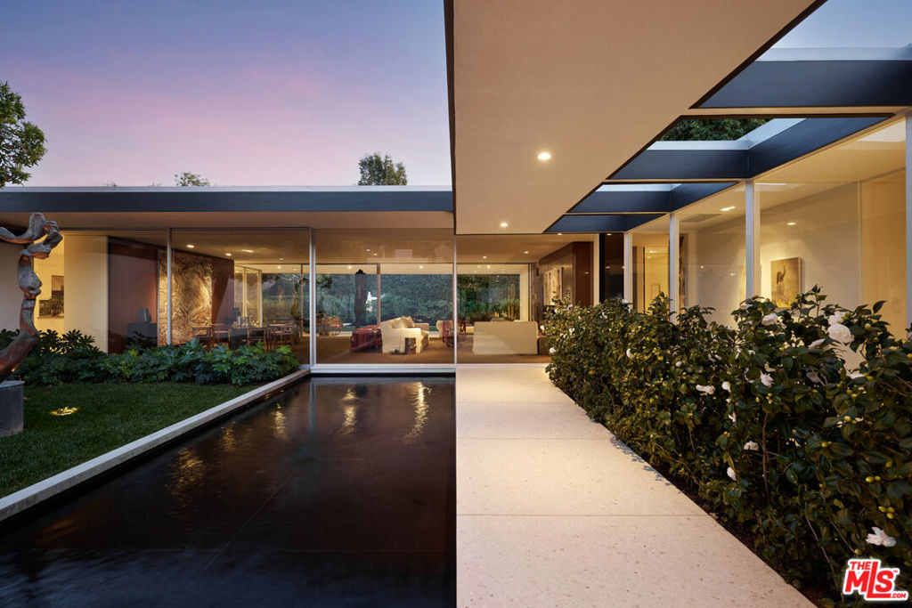 A Mid-Century Masterpiece by Donald Polsky, Meticulously Restored Nestled in a serene landscape, the Hillman Residence a striking mid-century modern home designed by Donald Polsky stands as a testament to the architect's tenure under the legendary Richard Neutra. Built in 1960, this residence encapsulates the modernist ethos with a seamless blend of form, function, and natural integration. A meticulous restoration by renowned designer Brad Dunning has preserved the home's architectural integrity while refining its timeless appeal. Complementing this vision, AD100 landscape designer Madison Cox has sculpted the exterior envelope with a thoughtfully restrained plant palette. His precise botanical composition accentuates the home's structural clarity, with a courtyard entry softened by Japanese aralia and camellia, offering a moment of tranquil transition. Beyond the images, one of the home's most compelling features is its immensely private, gated driveway courtyard a generous space that provides multiple secure entry points while ensuring an effortless flow between indoor and outdoor living. Celebrated for its architectural significance, the Hillman Residence earned a feature in Architectural Digest's February 2024 issue, reaffirming its place as a mid-century modern icon a home where history, design, and livability converge in perfect harmony.