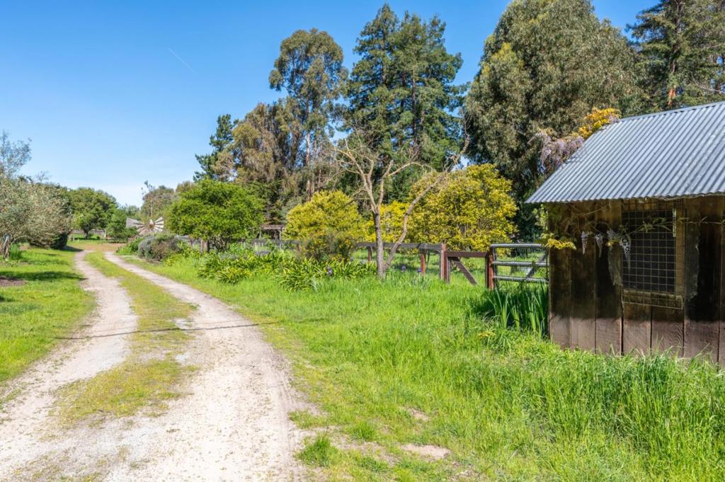 Discover your personal retreat on the sought-after Schulte Road in Mid-Carmel Valley. This 9.8-acre property features a charming farmhouse with a great room addition, showcasing a large kitchen with vaulted ceilings and skylights that meld modern functionality with classic farmhouse charm. A separate cozy two-room studio complements the main house with a workshop underneath, perfect for hobbies and passions. There's also a functional barn and a 1,200 sq ft two bedroom/one bathroom (laundry room too!) approved accessory dwelling unit (ADU), permit expired, offering the potential for rental income or shared living. The grounds include a garden space, a greenhouse ready for your vision, and a wisteria-draped pergola for serene afternoons. Envision raising chickens, keeping horses, and cultivating a thriving garden. With the peace of country living and just minutes from Carmel-by-the-Sea, this property is an ideal multi-generational compound or shared retreat, blending endless opportunities with coastal accessibility.