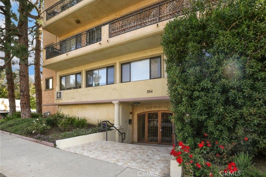 Modern, move-in ready 1BD/1BA with balcony in gated Brentwood Villas. Sunlit, north-facing, single-level home features an open living/dining area finished in oversized marble-look porcelain tile, crown molding, recessed/track lighting, and a ceiling fan. Designer kitchen with white quartz counters and a waterfall peninsula for stool seating; full-height travertine backsplash; custom dark cabinetry with glass uppers; matte-black faucet; double-bowl sink; pantry/utility niche; and a stainless appliance suite including a 5-burner gas range with chimney hood and dishwasher. The spacious bedroom offers bamboo flooring, a ceiling fan, and a walk-in closet with built-ins. Updated bath showcases a floating vanity with LED mirror, stone mosaic tile, and a tub/shower with glass enclosure. In-unit stacked laundry behind louvered doors. Private balcony overlooks a tree-lined street—perfect for morning coffee. Community amenities include a pool, dry sauna, renovated fitness center (2020), secure lobby with elevator, and gated entry; HOA includes earthquake insurance. One assigned gated parking space.
Additional highlights: a true cook’s kitchen with long prep runs and abundant cabinet storage—the peninsula doubles as a breakfast bar and serving counter. Expansive approx. 23-ft living room accommodates a full dining set plus a work-from-home nook; wide windows and smooth ceilings amplify light and volume. The bedroom fits a king bed with nightstands; the closet provides generous hanging and shelving. Practical upgrades include modern hardware and ceiling fans in both rooms. Exceptional location on a quiet, tree-lined street between San Vicente and Wilshire—moments to coffee shops, restaurants, markets, and the weekly Brentwood Farmers Market; convenient to UCLA, the Getty, Santa Monica beaches, and the 405/10. Approx. 728 sq ft per floor plan.