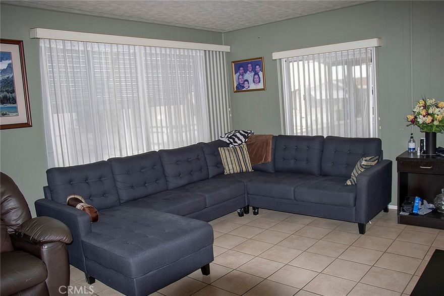 Welcome to this delightful mobile home located in the heart of Canoga Park! This cozy residence features a spacious covered patio, perfect for outdoor entertaining or relaxing. The yard is adorned with several fruit trees, adding natural beauty and freshness. Inside, you'll enjoy the comfort of central air conditioning, a newer water heater, and durable copper plumbing. There is a pantry in the kitchen that can hold many items. The home is very spacious, with two bedrooms and two bathrooms with a large living room that is open to the dining area. There is an additional area off the kitchen that has a sliding glass door that opens to the covered patio. This home also has a separate room that holds the washer and dryer with a door leading to the carport. It’s the perfect blend of comfort and convenience! There are two sheds outside for added storage.
