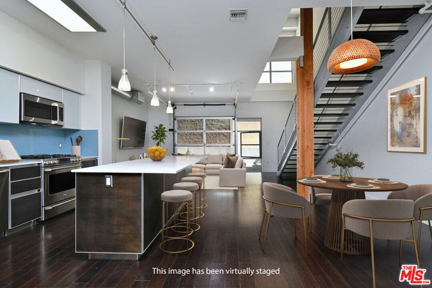 Modern West LA Living at It's Finest! This rare end-unit at T-Lofts delivers the ultimate in contemporary West LA loft living! Featuring soaring ceilings and expansive walls of windows, this two-story, 2-bedroom, 3-bath residence is bathed in natural light throughout. The open-concept design seamlessly connects the chef's kitchen to a spacious private patio with an electric roll-up door, creating an effortless indoor-outdoor flow ideal for entertaining or relaxing.The gourmet kitchen is appointed with beautiful cabinetry, Caesarstone countertops, stainless steel appliances, and a large center island. A versatile den on the main level offers the perfect home office or creative space. Upstairs, two bright bedrooms provide privacy and separation. The loft-style primary suite features a spa-inspired bathroom with double sinks, separate shower and tub, and a generous walk-in closet, while the secondary bedroom also includes an en-suite bath. Additional highlights include a main-level bathroom,, in-unit laundry, hardwood floors, recessed lighting, and numerous custom upgrades. Within the secured, beautifully landscaped, and eco-conscious community, residents enjoy resort-style amenities such as a hot tub with outdoor shower, BBQ area, fitness center, multiple outdoor seating areas, and package lockers, along with two side-by-side parking spaces, guest parking, EV chargers, and bike racks. Perfectly located in the heart of Sawtelle, this home offers unmatched access to LA's premier dining, shopping, and beachesthe perfect blend of modern design, luxury finishes, and effortless urban convenience.