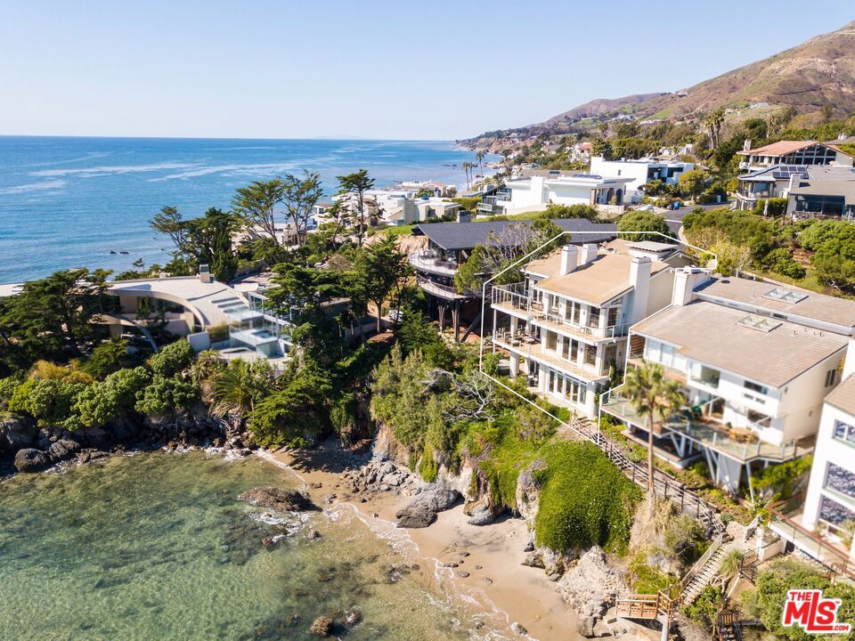 A true oceanfront retreat in the coveted gated community of Victoria Point! This multi-level enclave features jaw-dropping, panoramic ocean views from nearly every room. Gaze out to the waves breaking uniquely far from shore, passing sea life, and the sandy coastline of Broad Beach all the way to Point Dume. Enjoy direct access to a very secluded, sandy cove below which has beautiful rock formations, tide pools, sea caves, and a surf break. Inside, the light and bright interior is an idyllic blend of grand entertaining areas, lavish bedrooms, and peaceful spaces to unwind. The living room has vaulted, wood-beamed ceilings, a wet bar, oversized windows, and a causal flow that leads you out onto an oceanfront deck with unobstructed views. The kitchen includes a breakfast bar, dual ovens, and a walk-in pantry. On the second story, a lavish ocean view master suite boasts a fireplace, attached study/office, a private deck spanning the entire level, and an expansive bathroom with a soaking tub and walk-in closet. There is another guest bedroom on the second story, and two additional bedrooms on the ground level for family and friends, each with easy access to a magnificent oceanfront patio with a spa. A true gateway to the Malibu lifestyle, this prestigious, tropical-feeling sandy cove is one of Malibu's best-kept secrets.