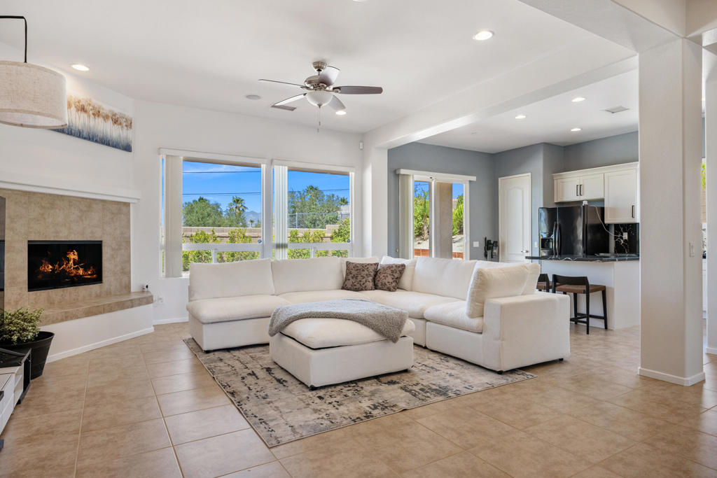 This charming Desert Hot Springs home sits atop a hill, offering sweeping valley views. Featuring 3 bedrooms and 2 bathrooms, the open and spacious layout is perfect for both entertaining and everyday living. Abundant natural light fills the home, while the inviting family room boasts recessed lighting and a cozy fireplace. The kitchen impresses with sleek white cabinetry, black marble-patterned countertops, a stylish island, and modern appliances. The primary bedroom is a tranquil retreat with glass doors leading to the backyard, a large en-suite bath with dual sinks, generous storage, and roomy closets. Additional bedrooms are equally bright and comfortable, sharing convenient access to a full hall bath. Outside, the backyard features a covered rear porch and a large lot, offering endless possibilities for relaxation or future enhancements. This home combines comfort, style, and stunning views--schedule your tour today!