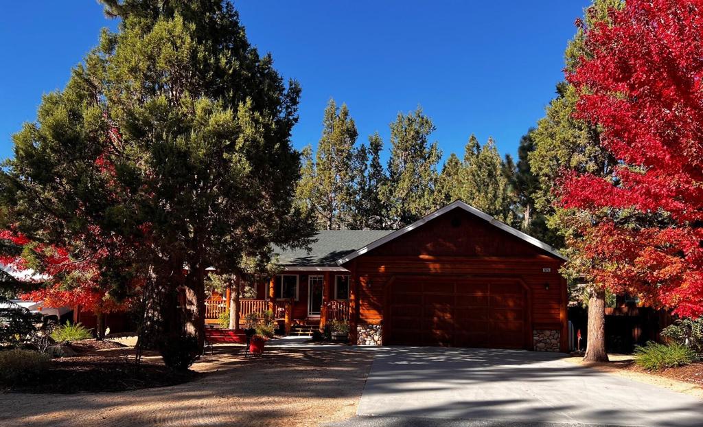 Partial FHA is assumable at 3.75%. GREAT BUY during uncertain times. Perfect getaway or full-time residence away from the desert heat.Family neighborhood. 12 minutes from ski resorts and lake! 15 minutes from Village.Gorgeous floor to ceiling stone fireplace welcomes anyone to this open floor plan. Large kitchen with a knotty pine ceiling and knotty pine half walls overlook the great room with bar seating for 6 six or more. Plenty of cabinets in the kitchen and more line the hallway. Stainless LG appliances, gas range. Spacious bedrooms. Master with knotty pine arched ceiling and partial walls. Barn style door opens to a walk-in closet. Additional 2 door closet in master. Enter from bedroom to a spacious double-sink bathroom.Every room offers a designer ceiling fan. Entire home has been custom painted with easy to clean satin finishes. Epoxy garage floor with finished walls and ceiling. Ladder to a finished attic that extends the entire length of garage. Great for storing holiday decor, files, off- season clothing and more. Lighting, shelves and carpet in attic.Wall mounted TVs in two bedrooms and a large movable TV in great room.Interior laundry room with LG appliances. Mature pine and maple trees surround the freshly stained log exterior. Back and front patios for enjoying morning coffee and watching birds and squirrels. Four seasons make a year into an experience with blooming flowers and trees in the spring, warm summer breezes and lake fun, colored leaves in the autumn, and snow-covered mountains in the winter. The village is always decorated per the season. There is simply no place like home when making this log cabin yours.