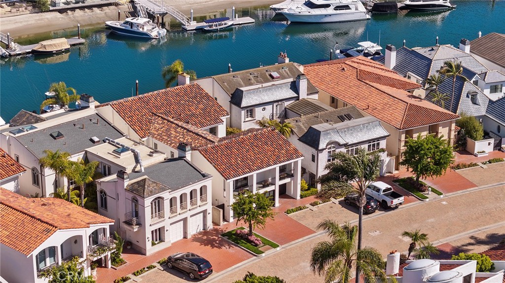 Located within the exclusive guard-gated enclave of Linda Isle, this distinguished bay front residence offers an unparalleled lifestyle of luxury and tranquility. Thoughtfully designed to capture the beauty of its surroundings and blending timeless architecture with breathtaking harbor views. A brand-new 50 ft private dock provides effortless access to the open water. Whether setting out for a day of yachting, paddle boarding through the scenic harbor or enjoying an evening cruise to Newport Beach’s premier waterside dining, this home offers an exceptional gateway to coastal living. The open and airy interiors are defined by soaring ceilings, expansive glass, and a seamless connection to the waterfront. Each of the four bedrooms features vaulted ceilings and en-suite bathrooms, with three offering private balconies that embrace the coastal breeze. The primary suite is a luxurious sanctuary, showcasing a private terrace with breathtaking bay views and dual en-suite baths designed for ultimate comfort. Residents of Linda Isle enjoy exclusive community amenities, including a private sandy beach, waterfront clubhouse, tennis court, play area, and guest dock. A rare offering in one of Newport Beach’s most coveted waterfront enclaves, this home embodies the essence of sophisticated coastal living.