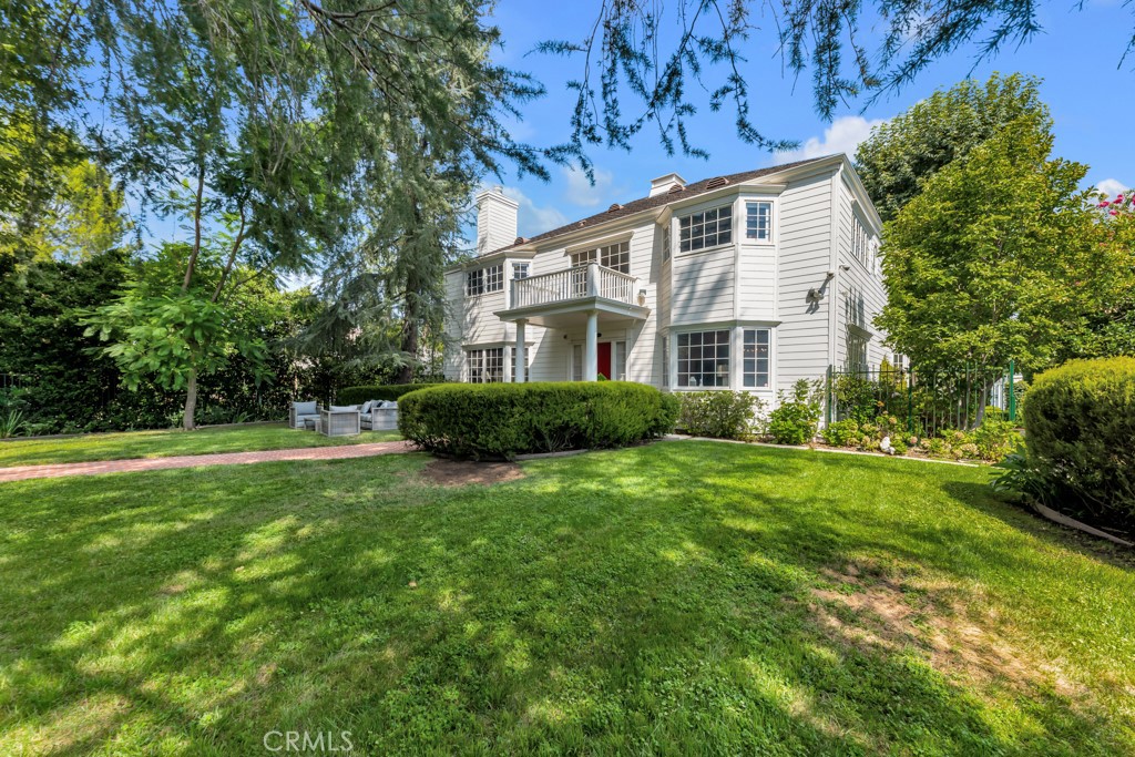 Tucked behind private gates in one of the most coveted South of the Boulevard neighborhoods, this stately Georgian estate sits on a rare, flat 18,546 sq. ft. lot surrounded by lush greenery and mature trees. Built in 1997 with timeless design and soaring 10-foot ceilings, this home offers both sophistication and warmth, blending classic elegance with everyday comfort. From the moment you enter the grand foyer, you’re welcomed into a home designed for entertaining and gathering. The formal living and dining rooms set the stage for memorable celebrations, while the spacious family room with its French doors leading to the gorgeous covered patio invite more casual moments. Overlooking a blooming rose garden, the kitchen features a center island, walk-through butler’s pantry, and abundant storage—making it the heart of the home. Upstairs, the primary suite is a private retreat, complete with French doors that open to an expansive balcony with sweeping views of the lush grounds. The spa-like bathroom offers a soaking tub, dual vanities, and a separate shower, while double walk-in closets provide ample space. A handsome library with built-ins and balcony access creates the perfect escape, and two additional en-suite bedrooms ensure comfort for all. The outdoors feel like a private sanctuary. A sparkling pool with automatic cover is ideal for long summer days, while the expansive grounds include an enclosed vegetable garden with raised beds and an orchard of fruit trees—apple, avocado, pomegranate, citrus, and walnut to name a few—bringing both beauty and bounty. A charming 400 sq. ft. GUEST HOUSE with its own kitchen, bath, and French doors offers the perfect space for visitors, home office or creative pursuits. Minutes from Ventura Blvd. with shops and entertainment, El Caballero and Braemar Country clubs and easy access to 101 freeway. With its rare combination of space, privacy, and timeless style, this estate is more than a home—it’s a lifestyle.