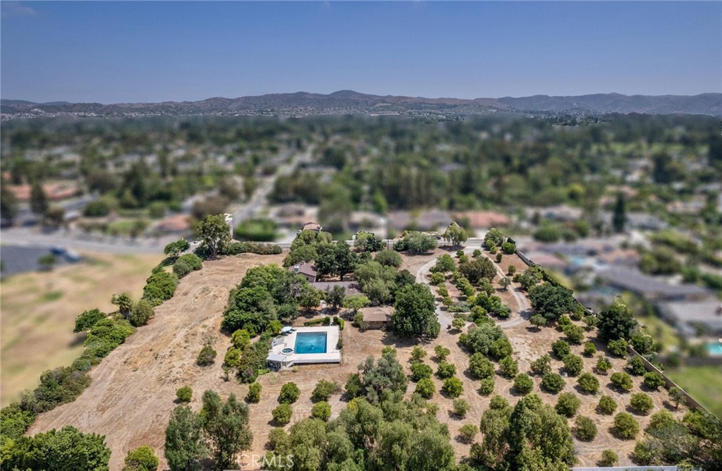 Magnificent One-of-a-kind property in the heart of Yorba Linda ~ First time on the market in over 50 years ~ Charming 5 bedroom adobe pool home situated on 3.7 acres (approx.) of citrus trees and secluded grounds ~ Superb craftsmanship in this home featuring stone floors, wood beamed ceilings, wood framed French doors and windows and vintage stone fireplace ~ The original home was built in 1946 (per title) and has been remodeled and additional living space was added in 2001 (approx). Remodeled kitchen features a spacious island, greenhouse window, apron sink, 5 burner gas stove with range hood, self-closing custom cabinetry, granite and quartz counters and a wine frig. ~ Distinctive living room and dining room with unique architecture and views of the surrounding land ~ Primary bedroom with stone fireplace, beamed ceilings, wood flooring and casual seating area ~ Spacious remodeled primary bathroom with an oversized shower and huge walk in closet ~ Additional 2 bedrooms are ample in size and share a hall bathroom ~ Upstairs features a bonus room, 2 additional bedrooms and a bathroom ~ Tranquil pool and spa surrounded by the majestic surrounding grounds ~ 2 car detached garage with ½ bath ~ Covered front and rear patios to relax and enjoy the tranquility and serenity of the vast wide open spaces and stately trees that brings country living to you ! This is a spectacular property and there is nothing else like it in Yorba Linda.
