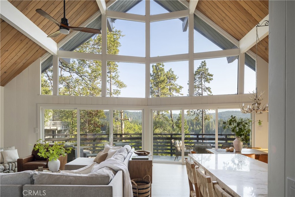 Perched in a prime first tier location, this fully renovated lake view retreat offers the perfect blend of style, comfort, and adventure. With a coveted ½ double dock just a short walk away, this home is your gateway to unforgettable lake days filled with swimming, boating, and relaxation. From the moment you walk in, natural light pours through expansive windows, perfectly framing the stunning lake views. The heart of the home is the open-concept main level, where a fully upgraded kitchen, dining, and living space come together seamlessly. Just beyond, an expansive wrap-around deck invites you to dine outdoors, relax with a morning coffee, or watch the sun set over the water. The main level also features two large bedrooms providing plenty of space for your guests. Upstairs, the primary suite serves as your own personal retreat, offering the ultimate privacy. The lower level has been transformed into a versatile lounge and game room, complete with a wet bar and its own private entrance which is ideal for hosting guests or offering extra sleeping space. Need even more space? This home also includes a detached guest house with its own kitchenette and bathroom, offering privacy and flexibility for visitors or rental potential. Outside, the magic continues. Take a relaxing soak in the hot tub or follow the trail right across the road from the house, leading you to your own ½ double dock. The oversized garage is built with function in mind, providing space for two cars, golf carts, and a work area. With plenty of room for tools, toys, and gear, you’ll be ready for every lake day or mountain excursion. Whether you’re searching for a full-time residence, a weekend retreat, or a high-performing rental, this property checks every box.