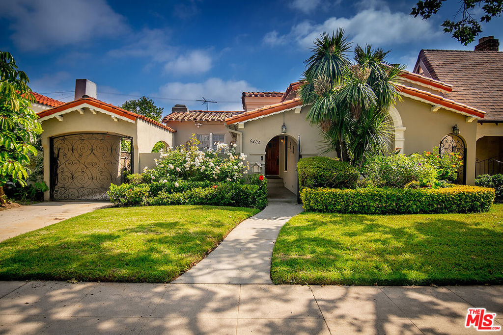 STYLISH COURTYARD SPANISH WITH POOL IN BEVERLY GROVE. Enter this character-rich home through a private courtyard and foyer leading to a grand living room with beamed ceiling, period stained-glass picture window, peg-and-groove hardwoods and fireplace. There is a large formal dining room with French doors leading to a side patio, a period kitchen with separate breakfast room and laundry room with side entry. A wide central hallway with skylight leads to three generous bedrooms, a period primary bath with separate tub and shower and a second guest bathroom. A heated pool, lounge area and fabulous pool house complete the home. Additional features include French windows, crown moldings, articulated ceilings, archways and built-ins, central AC and an automatic driveway gate. This is an incredible offering in an ideal location!