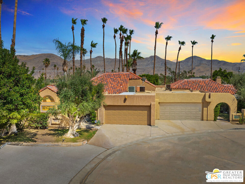 Set at the beginning of a quiet culdesac in the gated Canyon Heights community, this 2 bedroom, 2.5 bath townhome sits on fee land. Inside, it's all about volume and light: soaring vaulted ceilings, a sunken living room with a fireplace, plantation shutters and gleaming tile floors. Two primary suites (one on each level) make hosting guests or multigenerational living a breeze - But the showstopper is the approx.1,000 sqft patio, the only one of its kind in the complex. It looks out over mountains and desert skyline and offers direct gated access to the pool/spa, tennis courts and clubhouse. A lava rock fire pit and water feature sets the mood for sunset cocktails or morning yoga. The attached 2-car garage is air-conditioned, so it doubles as a studio or workshop. The very desirable Canyon Heights itself is resort-like: you get four pools, four spas, three tennis courts, four pickleball courts and a clubhouse, all tucked against the San Jacinto Mountains with hiking trails right outside your door - no vehicle needed! Indian Canyon Golf Courses and Smoketree Village are just down the road for a quick round or dinner out. HOA fees are $723 a month. If you're searching for space, privacy and amenities in south Palm Springs on land you own, this condo checks all the boxes. Bring your inner entertainer and a love for desert skies; this home is ready for its next chapter!