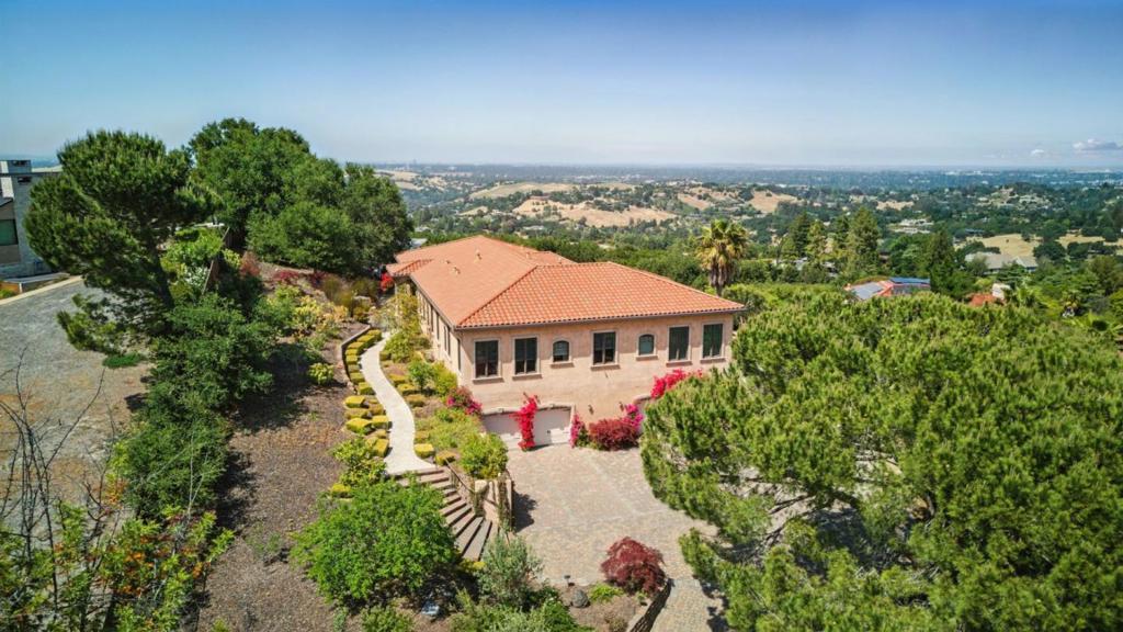Prepare to be captivated by the breathtaking panoramic Bay views from this exceptional custom residence, gracefully perched on ~1.3 acres at the end of a private cul-de-sac. Behind a gated driveway, this Tuscan-inspired estate is designed to maximize its extraordinary vantage point offering extraordinary sweeping vistas. A grand entry with impressive double doors opens to elegant, view-framed living spaces, where high-end finishes and impeccable craftsmanship define the homes elevated style. The main level is thoughtfully designed for everyday comfort and effortless entertaining, with a formal living room, dining room, and a spectacular chefs kitchen that opens to a spacious family roomall enjoying unobstructed Bay views. Three generous en-suite bedrooms, including a luxurious primary suite with a spa-like bath and large walk-in closet, offer serene retreats on the main level. The lower level features a fifth bedroom or office, perfect for guests or work from home, plus a large theater room with wet bar. Outdoors, resort-style amenities await: a sparkling pool, lawn, sport court, and expansive patios all perfectly positioned to soak in the awe-inspiring scenery. A rare opportunity to enjoy luxury living with one of the most stunning Bay views Los Altos Hills has to offer.