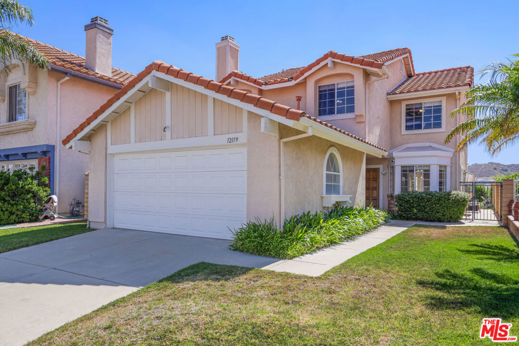 Nestled within the highly sought-after Porter Ranch Estates, this beautifully maintained 4-bedroom, 3-bathroom residence offers a perfect blend of comfort, space, and security, all set against a backdrop of sweeping city and mountain views. Located in a prestigious 24-hour guard-gated community, this light-filled home showcases an inviting floor plan designed for effortless everyday living and elegant entertaining. Step through the grand double-door entry into a welcoming foyer adorned with gleaming tile floors and an abundance of natural light. The spacious formal living and dining areas are framed by oversized windows that fill the home with warmth and offer serene views of the lush backyard and surrounding hillsides. These open-concept spaces create a seamless flow ideal for gatherings both large and small. The generously sized chef's kitchen features classic granite countertops, ample cabinetry, and a cozy casual dining area, making it a hub for meal prep and family time. Just beyond, the comfortable family room offers a cozy fireplace and direct access to the attached two-car garage, along with sliding doors that lead out to the backyard, perfect for indoor-outdoor living. Also on the main level, you'll find a bathroom and a dedicated laundry room with extra storage, enhancing the home's everyday functionality. Upstairs, retreat to the expansive primary suite, a true sanctuary with large windows that frame panoramic views, a spacious walk-in closet, and a private en-suite bath. Three additional upstairs bedrooms offer plenty of space for family, guests, or a home office, and share a well-appointed hall bathroom. Outside, enjoy a grassy backyard oasis with ample room for play, relaxation, and al fresco dining all with unobstructed city lights and mountain views that create a picturesque setting from dawn to dusk. Experience the ultimate in resort-style living with community amenities such as a shimmering pools, relaxing spa, designated BBQ areas, and scenic picnic spaces. You'll also love the convenience of being near the lively Vineyards shopping center, home to popular dining spots like Lure Fish house and Patxi's Pizza, upscale retailers like Whole Foods, and a modern AMC theater for all your entertainment needs.
