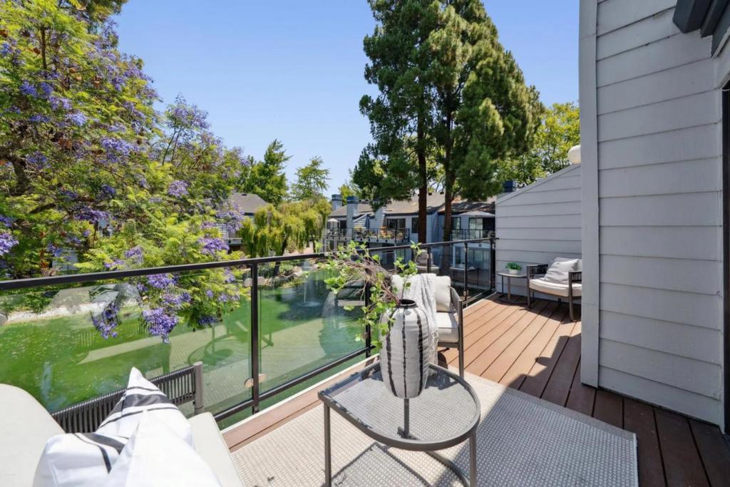 Located in the tree-studded community of The Waters, this top-floor unit at 905 W Middlefield #924 pairs updated interiors with peaceful pond views and a convenient Mountain View location. Vaulted ceilings and fresh paint enhance the open-concept living space, which includes a fireplace and a balcony with modern glass-and-metal railing. The refreshed kitchen features new quartz countertops, painted cabinetry, updated lighting, and stainless steel appliances, while the adjacent dining room features a striking modern chandelier. Two bedrooms enjoy southern exposure and leafy outlooks; the primary includes an ensuite bath with updated vanity, tile flooring, and lighting. The secondary bathroom mirrors these updates and sits beside the second bedroom. Other features include in-unit laundry, abundant storage, and new lighting throughout. A detached garage provides dedicated parking and storage. Enjoy community amenities including pool, hot tub, and tennis courts, plus proximity to parks, Castro Street, and Caltrain.