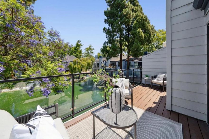 Located in the tree-studded community of The Waters, this top-floor unit at 905 W Middlefield #924 pairs updated interiors with peaceful pond views and a convenient Mountain View location. Vaulted ceilings and fresh paint enhance the open-concept living space, which includes a fireplace and a balcony with modern glass-and-metal railing. The refreshed kitchen features new quartz countertops, painted cabinetry, updated lighting, and stainless steel appliances, while the adjacent dining room features a striking modern chandelier. Two bedrooms enjoy southern exposure and leafy outlooks; the primary includes an ensuite bath with updated vanity, tile flooring, and lighting. The secondary bathroom mirrors these updates and sits beside the second bedroom. Other features include in-unit laundry, abundant storage, and new lighting throughout. A detached garage provides dedicated parking and storage. Enjoy community amenities including pool, hot tub, and tennis courts, plus proximity to parks, Castro Street, and Caltrain.