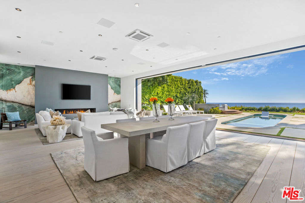 Paradise found on the Encinal bluffs. Experience breathtaking, panoramic ocean and whitewater views from Catalina to the Channel Islands at this exceptional oceanfront retreat on approximately .65 acres on Malibu's ultra desirable Encinal Bluffs. This estate is a masterclass in relaxed coastal luxury, singularly beautiful, exquisitely appointed, and designed to capture year round sunsets in their full cinematic glory. Tucked behind dual gates for maximum privacy, this hi-tech contemporary residence welcomes you with beautifully curated landscaping and soaring ocean views from nearly every room. At the heart of the home, a 36-foot motorized wall of glass seamlessly transforms the expansive living, dining, and kitchen area into a stunning oceanfront resort, featuring a pool with Baja shelf and spa, outdoor bar/kitchen, al fresco dining area, a large circular firepit lounge, all tailored for memorable moments and effortless hospitality. Each evening, the horizon becomes a living canvas of fiery golds, soft purples, and deep blues washing over the ocean in an intimate and infinite sunset show. A second, more secluded firepit rests atop the bluff, where a private path leads down to your own sandy cove, complete with Adirondack chairs and lush, flowering greenery. Inside, a light-filled open floor plan blurs the line between indoor and outdoor living. European wide-plank wood flooring and soaring ceilings create an airy, expansive atmosphere. The great room is anchored by a dramatic fireplace set in back-lit Brazilian marble, flanked by a built-in humidor and a temperature-controlled wine closet, custom crafted for seamless entertaining. The sleek chef's kitchen inspires culinary creativity with touch-open European cabinetry, Gaggenau appliances including steam and wall ovens, and a built-in coffee system. A cozy media room, showcasing a fur covered couch, can be tucked away for added privacy by a stylish, sliding barn door. A full bath and laundry room complete the main level. From the dramatic double height entry hall, floating stairs ascend to a spacious upper landing with a sitting area. Three well-appointed bedrooms await each featuring automated window shades, private deck access and an ensuite bath for effortless comfort and privacy. The ocean and pool view primary suite is a refined retreat, featuring dual closets and a spa-inspired bath with a glass-encased ocean facing rain shower, designed for indulgence. Additional features include garage, guest parking, an outdoor shower, integrated solar power, and a suite of smart home amenities including security and sound systems. With its blufftop setting and striking design, this contemporary estate takes the Malibu lifestyle to new heights.