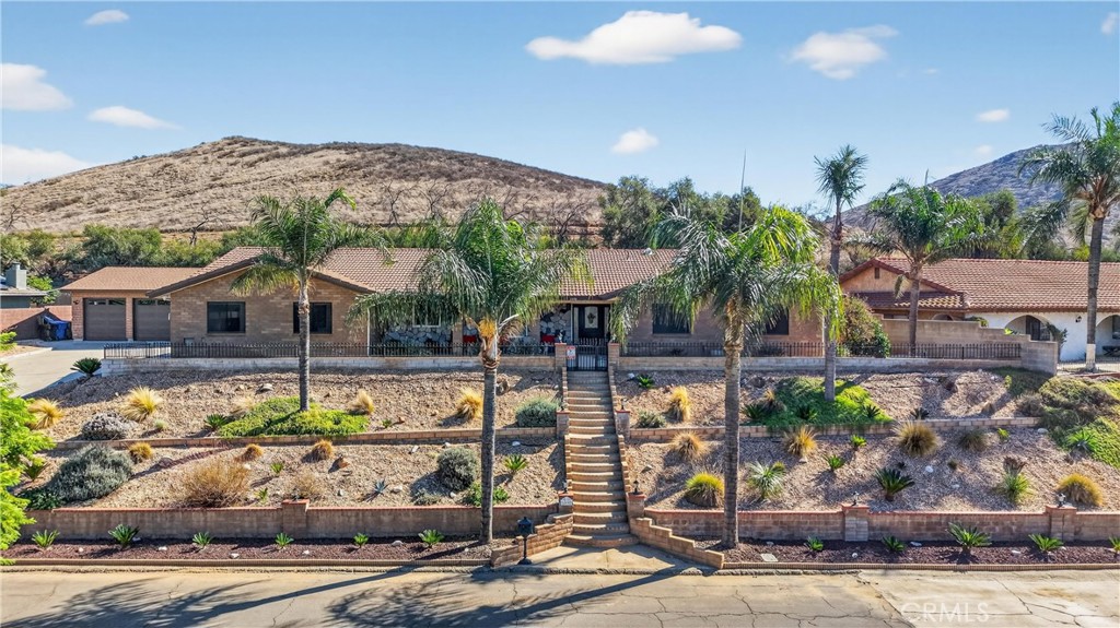 Discover 2,487 sq ft of fully remodeled bliss on a massive lot, framed by the San Bernardino Mountains. This single-story gem delivers open-concept living, boundless storage, and an epic entertainer's backyard – perfect for families and fun. Golden natural light pours through energy-efficient windows into a soft neutral palette, where luxury vinyl plank flooring flows throughout and central AC/heating ensures year-round comfort. The chef's kitchen shines with sparkling quartz counters, a large center island, 48" double oven, with a swing arm pot filler faucet, stainless steel appliances, farmhouse sink, and crisp white shaker cabinets under chic globe pendants. It flows seamlessly to the dining area with built-in hutch and family room anchored by a dramatic stone fireplace. Four spacious bedrooms feature ceiling fans and ample closets, paired with 2.5 spa-inspired bathrooms offering dual vanities, frameless glass showers, subway tile, with modern fixtures. A private indoor laundry adds everyday ease. Storage is unmatched with a 565 sq ft attached garage (220 sub for welding) plus a massive 3-car detached garage with a custom built (12x25 alumawood carport) – perfect for RVs, boats, workshops, or home gym.  The backyard oasis captivates under a covered patio with string lights, built-in outdoor kitchen (gas grill, sink, bar seating), regulation pool table, bubbling spa, fire pit seating, 4 large storage sheds, artificial turf lawn, mature citrus fruit trees, dog run, paver paths, secure fencing, and stunning mountain views. Curb appeal dazzles with a durable tile roof, swaying palms, terraced drought-tolerant gardens, and grand entry staircase. Nestled on a quiet street near top schools, parks, hiking trails, shopping, dining, and freeways. Move-in ready with newer windows, electrical, plumbing, lighting, HVAC and solar-ready panels. This rare Riverside treasure won't last. Schedule your private showing TODAY!