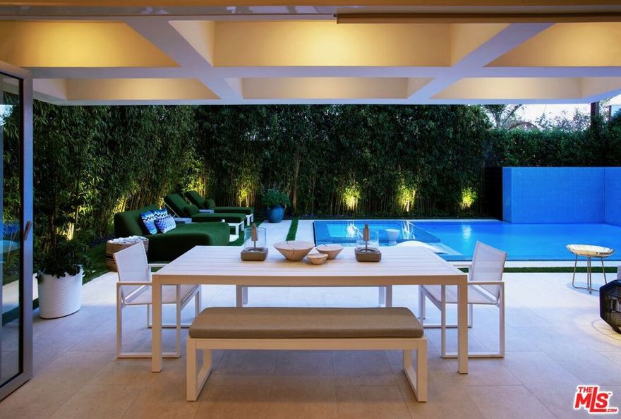 The perfect blend of warmth and contemporary living in this exceptional residence epitomizes the quintessential California lifestyle. Nestled behind a row of stately olive trees and private gates is a south-facing home bathed in an abundance of natural light from every space. The expansive home spans nearly 4,000 square feet, featuring 4 bedrooms and 4 baths. Soaring ceilings and open-concept living space opens to the chef's kitchen adorned with impeccable finishes and top-of-the-line stainless steel appliances. Glass accordion doors connect to the outside, revealing a resort-like backyard with a zero-edge infinity pool, spa, charming atrium and fire pit, perfect for entertaining.  The voluminous primary suite is complete with 14 foot ceilings, a walk-in closet, balcony, black out curtains, and a spa-inspired bath with a 5-function smart shower. Two additional large en-suite guest bedrooms and a laundry room complete the upper level. To complete this remarkable residence is state-of-the-art smart home technology including keyless and fingerprint entry, an elaborate security camera system, a surround-sound speaker system, as well as dual-zoned AC with NEST thermostats. The two-car garage is outfitted with a modern built-ins and an EV charge station, offering the perfect synergy of sustainable living and modern convenience.