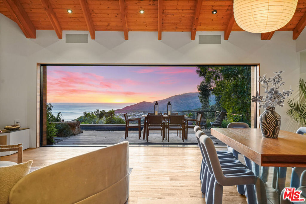 Welcome to Paseo, an Artist's California Modern Ocean View Aerie and Studio in the exclusive neighborhood of Paseo Miramar. There are places that nurture the creative spirit. This is such a place. A former residence of a Beach Boy, the home was completely reimagined in collaboration with Architect Bill Bernstein, an associate of the incomparable Mexican Architect, Ricardo Legoretta, renowned Designer Megan Heacock White, and the Artists/Owners. The home was completely rebuilt, save the decision to retain the roof that sheltered a Beach Boy and contained those good vibrations. The house was recreated as an open, airy, rigorous yet organic retreat with a Mid-Century feel. The setting is spectacular.Wood gates shield the Cedar clad architectural masterpiece and bold 2 story artist's studio. Extraordinary vistas of the lush canyon, mountains, and the sea expand outwards from the soulful, cascading gardens, wide, welcoming Ipe decks, and a serene pool. A spa nestles in the verdant hillside. Your future is here, enveloped in this home created as a refuge, a sanctuary, an art piece in its own right. The property melds function and flow with beauty. An open living space yields breathtaking views, with an expanse of sliding Fleetwood doors that pocket into a wall, eliminating divisions between inside and out. These views inspired a design journey of harmonizing vintage charm with modern appeal and a deep connection to the surrounding landscape.A wide open, custom Chef's kitchen, with an island both welcoming and practical, invites shared conversations, and the breaking of bread together. Wine drawers store select vintages. Elegant Walnut cabinets have storage for every need. Sleek appliances and limestone counters and sinks are sturdily beautiful. Light pools on the island from original handmade ceramic pendants. Across the driveway is every artist's dream, a huge studio with perfect light, walls of glass, polished cement floors, high ceilings, wraparound decks, and a huge powder room that could evolve into a full bath. Divided into 2 huge studios, it could become one huge studio. Down an exterior wood staircase, another light filled, high-ceilinged space is a perfect office, with adjoining storage rooms. The landscaping is reminiscent of central coast resorts; waterfalls tumble, paths meander, Hummingbirds and butterflies flit about, fruit trees nourish. A short drive away, the beach beckons. Nearby trails lead into the park. The Palisades village, with its charming farmer's market, exclusive shops, and foodie restaurants is nearby. But here, in your private world, you are away from it all.