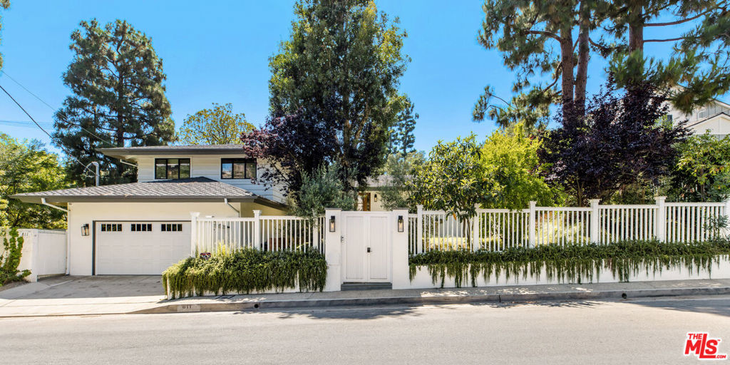 This beautifully updated residence offers luxurious, private living on a peaceful off-street, set behind a fully fenced lot. Designed for indoor-outdoor living, the home features two expansive outdoor areas one with a lush grassy yard, built-in BBQ, fire-pit, and al fresco dining space, and the other with a serene pool surrounded by mature greenery and privacy. Inside, an inviting entry leads to a stylishly remodeled powder room and into a bright, open-concept main level. The spacious living room, custom kitchen, and dining area all enjoy seamless access to the backyard through large windows and sliding glass doors, creating an effortless indoor-outdoor flow. The chef's kitchen is appointed with stone countertops, a custom island, high-end stainless steel appliances, and a generous breakfast bar ideal for casual dining or entertaining. Wide-plank hardwood floors run throughout, leading to a cozy family room that's perfect for everyday living or hosting guests. The lower level includes two well-sized bedrooms, a second living area with an additional fireplace, and a dedicated laundry room. Upstairs, you'll find three more bedrooms, including a private primary suite with an updated bathroom featuring a soaking tub that overlooks the surrounding natural landscape. Available for a one-year lease or longer. Premises may be furnished at a higher rent, if agreed before lease start.