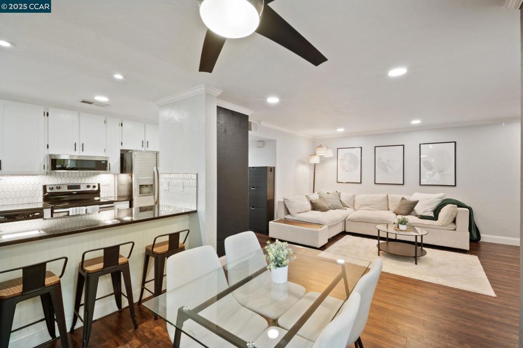 This FULLY UPDATED end-unit home has been thoughtfully upgraded with designer paint, blinds, luxury vinyl plank flooring throughout, and IN UNIT laundry! The kitchen features a new microwave, backsplash, shelving, automatic glass rinser, built-in wine fridge, and all appliances—including the washer, dryer, and refrigerator—convey. Featuring 2 bedrooms and 2 fully remodeled bathrooms, the primary suite offers a spa-like retreat with dual shower heads, an LED lighted mirror, and a custom closet organizer. Step outside to your private patio and enjoy beautiful string lights while relaxing or entertaining. Additional highlights include a cozy wood-burning fireplace, Nest smart-home features, a one-car garage plus an assigned carport, and HOA-covered water, garbage, cable, internet, and 2 swimming pools! This move-in ready home combines modern updates with a warm, inviting atmosphere—perfect for enjoying all that the community has to offer.