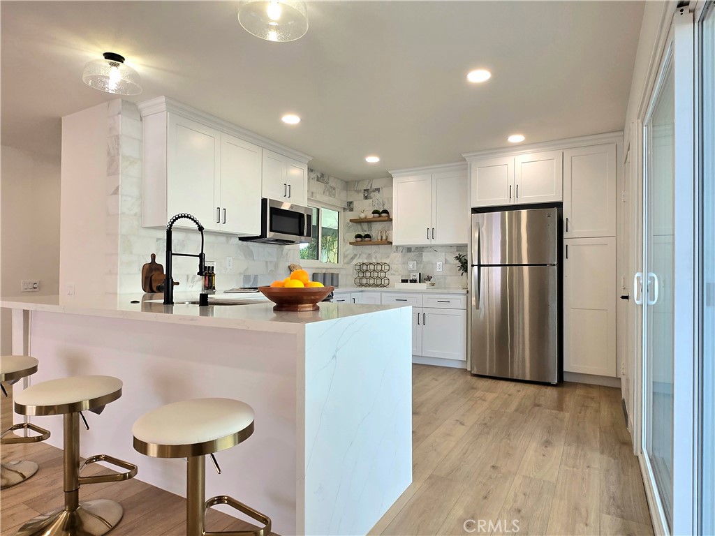 Welcome to your practically Brand New home on Jaelene Street! Unique location with complete privacy, fully mature landscaping, and beautifully upgraded from the inside out. This home boasts a Brand New 5-ton Lennox HVAC System, Newly replaced roof, and views of the San Jacinto Mountains. Step inside and you will discover an exceptionally large open concept living space flooded with recessed lighting, gorgeous tiled fireplace and mantle, light oak flooring and white dual pane windows and slider. The kitchen is a chef's and entertainer's dream featuring new White Shaker Soft Close Cabinets with a Pantry and 2 Lazy Susans, Complete Wrap around Peninsula with Waterfall Quartz countertop, Honed Marble backsplash wrapping around the window finished with floating shelves and all new GE Stainless Steel Appliances including a flat top oven range, microwave, dishwasher and refrigerator. Bedrooms feature recess lights on dimmer switches, LED Ceiling fans, a Walk-In closet in the Master Suite and mirrored closet doors in the 2nd bedroom. Both bathrooms are completely updated with new Fluted Wood Vanities, Mirrors, Lighting and a new Chrome shower door in the guest bath, which has its own private access from the secondary bedroom, making it a potential secondary ensuite. 3rd room has a double door entry and can be used as an office or guest space. The Indoor Laundry Room has plenty of cabinetry and countertop space for storage and folding, honed marble backsplash matching the kitchen, newer water heater, and also includes LG Diamond Glass Edition Washer & Dryer. Rare enlarged 2 car garage with plenty of storage space and newer contemporary paneled garage door with windows. Fresh Interior and Exterior Paint complete with modern lighting, security system, extended concrete driveway and backyard patio with drainage. With too many upgrades to list, this GEM checks ALL the boxes and is a MUST SEE true definition of finer living in Menifee's most desired 55+ Community with Low Taxes & HOA.