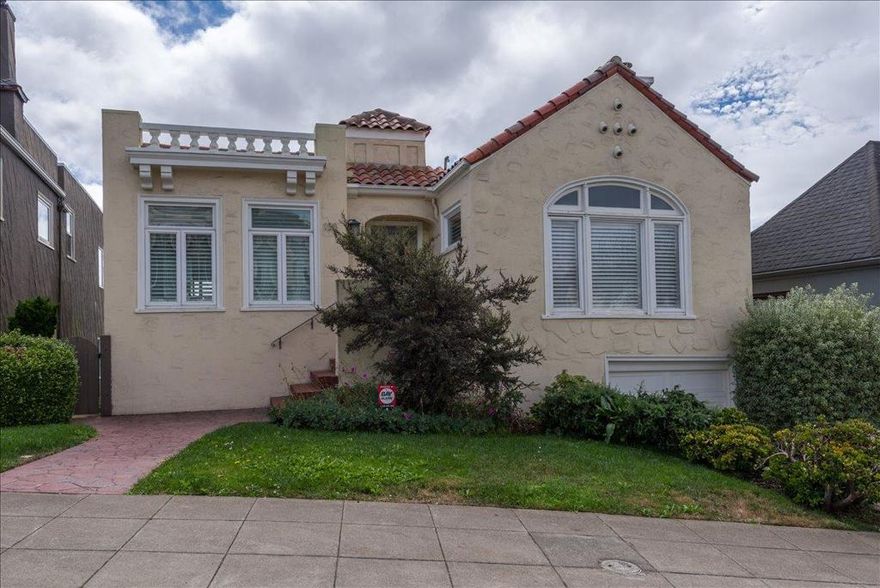 Nestled in Mt. Davidson Manor, this Spanish Mediterranean home blends timeless style with modern comforts. Across three levels, this four-bed, four full and two half-bath residence is perfect for entertaining, relaxation, and everyday living with lovely city and ocean vistas. The main level presents a grand living room featuring recessed ceilings, a wood-burning fireplace, and beautiful hardwood floors. An elegant dining area flows into a generous kitchen with granite counters, Bertazzoni range, and ample storage.  Two bedrooms, including a serene primary suite with charming views and a spa-inspired bath, complete this floor. The middle level is designed for both gathering and retreat, with a spacious family room opening to a deck for indoor-outdoor living. This level also includes two bedrooms, 2.5 baths, laundry, and access to both the garage and a separate exterior entrance. The lower level offers a flexible media room with half bath and access to a large deck overlooking a terraced yard.  The backyard features multiple zones for entertaining and play, with tiled patios, and garden areas. A short stroll to Ocean Avenues shops, cafés, Whole Foods, and public transit, with quick access to 101/280, this home offers comfort and convenience in a serene San Francisco neighborhood.