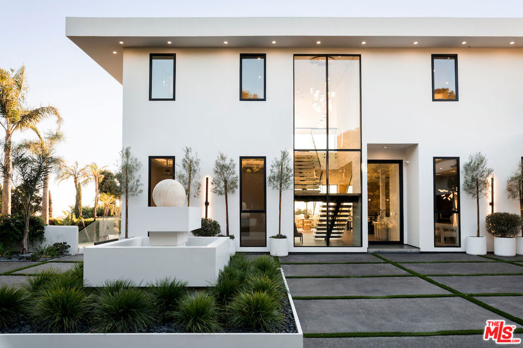Discover a Malibu New Construction Ocean View estate minutes from Point Dume and set on over 2 acres of spectacular lush landscape and a vineyard. At the end of a private cul de sac, this exceptional Modern Organic luxury estate is a serene compound with commanding views of the Pacific Ocean, rolling vineyards, and the Santa Monica Mountains. From the moment you arrive, the estate makes a statement with its gated and circular motor court and elegant approach that sets the tone for the sophistication within. Soaring ceilings, walls of glass, and expansive open living spaces seamlessly blur the lines between indoors and out, while over 3,000 square feet of wraparound ocean view decks invite you to take in the ever-changing ocean and Tuscany inspired 1 acre vineyard vistas. Every detail of the estate has been carefully curated with the highest level of craftsmanship and design. Fleetwood windows and doors frame dramatic sight lines, while custom white oak built-ins, handmade zellige tiles, and striking stone selections such as Taj Mahal quartzite and leathered granite create a refined, organic palette throughout. The open-concept living area flows effortlessly into the chef's kitchen featuring a 12-foot island clad in leathered stone, top-of-the-line Miele appliances, lime-washed walls, and a large walk-in pantry. The thoughtful floor plan offers five bedrooms and five bathrooms, including two bedrooms on the main level. Upstairs, the primary suite is a true sanctuary with dual closets, a private sitting room, and a spa-inspired bath dressed in Taj Mahal quartzite. The upper level also includes two additional bedrooms and a spacious family lounge designed for relaxed living. An elevator connects both levels with ease. World-class amenities elevate the lifestyle experience, including a state-of-the-art home theater, wine cellar, stylish bar and lounge, and an innovative indoor/outdoor gym that makes fitness a daily indulgence. The outdoor spaces are equally captivating. Resort-like grounds feature a sparkling pool and spa, built-in fire pit, custom barbecue, and an expansive grassy pad of nearly 4,000 square feet with a golf practice area ideal for entertaining, recreation, or simply soaking in the tranquility of your surroundings. The property has been designed for convenience and security, with a four-car garage, video intercom system, and ample additional parking for over 10 vehicles, including space for an Airstream or boat via private side yard access. This secluded estate represents a rare opportunity to own an ocean view retreat in Malibu, complete with a uniquely picturesque vineyard, perfectly positioned near Point Dume and Malibu beachside conveniences.