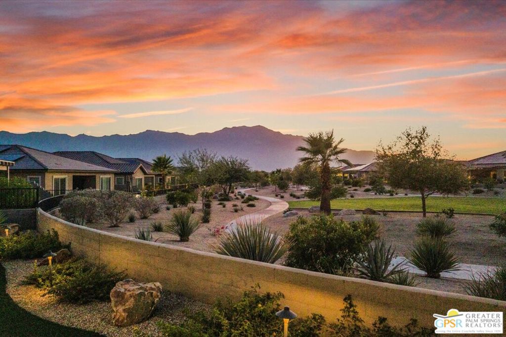 VIEW, VIEW, VIEWS! Enjoy breathtaking panoramic mountain views from this exceptional Phase 2, Plan 8 Serenity floorplan with the stylish Prairie facade, perfectly positioned on a sprawling 1/4-acre+ lot. This highly upgraded home includes the desirable two-bedroom junior suite configuration with two and a half baths, a dedicated den/office, and an expanded bay-window primary suite for added elegance and space. Step inside to an expansive layout enriched by thoughtful, high-end upgrades including 12"x24" designer tile, plush upgraded Berber carpet, and 7 1/4" baseboards throughout. The chef's kitchen is a showstopper - featuring upgraded full-height floor-to-ceiling cabinetry with crown molding, a premium KitchenAid appliance package with dual ovens, a statement-making full tile backsplash, Valentino White quartz countertop with triple edge, and an oversized executive island offering abundant storage, bar seating, and striking hand-selected pendant lighting. The kitchen seamlessly flows into the generous great room with soaring 12-foot tray ceilings, quad-panel accordion glass sliding doors, and custom LED lighting - creating a light-filled, open-concept living space that brings the outdoors in. The luxurious primary suite offers a tranquil retreat with its expanded bow window with stunning views and spa-inspired ensuite bath adorned with upgraded tile work, modern brushed nickel fixtures, and a large walk-in closet. Perfect for guests, the junior suite is ideally located on the opposite side of the home and features a spacious bedroom, private full bath, and ample closet space for ultimate privacy. The fully landscaped backyard is an oasis with captivating mountain vistas, a covered patio with motorized zipper shade, a personal putting green, and generous side yards - plus direct access to scenic walking paths and the community's unmatched amenities. Additional highlights include: Leased solar system with 16 panels ($115/mo), Tech package with Wi-Fi extender and high-speed outlets in key rooms, Expanded dining area, Large den/office with tray ceiling, Oversized laundry room with utility sink, and a Massive extended garage (25'-35' deep), ideal for oversized vehicles or 3-car storage. Del Webb Rancho Mirage is a premier 55+ active adult community offering resort-style living with pool, spa, fitness center, clubhouse, social events, and so much more. Don't miss this rare opportunity to own a highly upgraded view home in one of the community's most desirable locations. Please note: Cabinetry may appear darker in photos than in person.