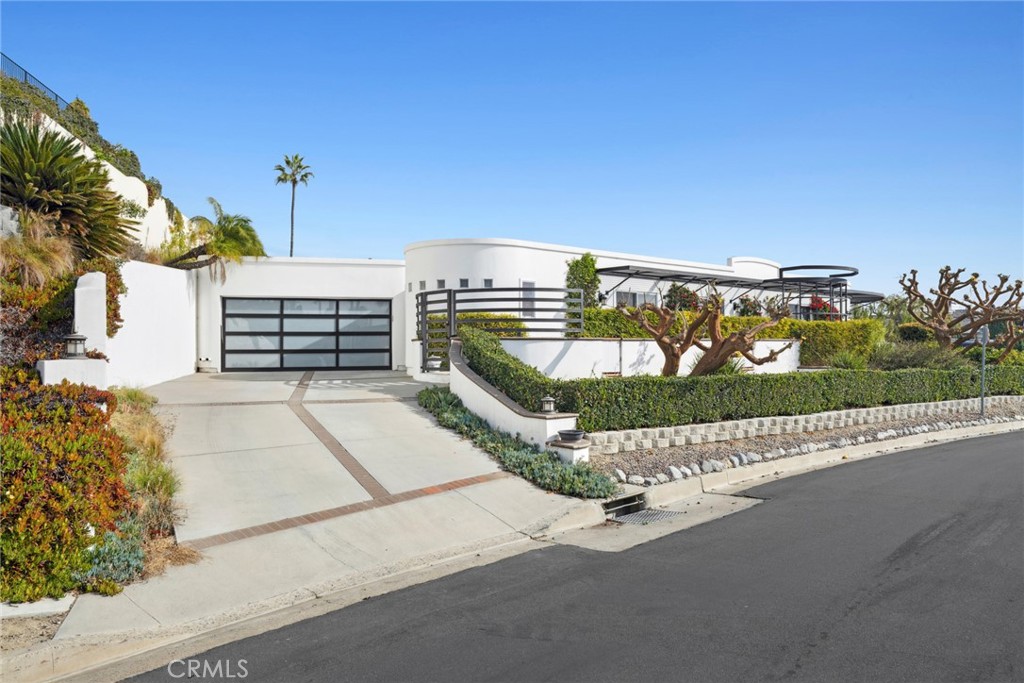 Newly remodeled. New photos coming soon! Situated in the prestigious Mystic Hills neighborhood of Laguna Beach, this 3,038 square foot custom home, mostly single level, boasts opulent amenities and abundant space for entertaining. Luxury defines the three-bedroom, two-and-a-half bath residence, showcasing top-notch finishes, ranging from meticulously hand-crafted millwork to skylights that enhance the overall aesthetic. The well-thought-out floorplan seamlessly blends indoor and outdoor living, creating an inviting atmosphere. French doors open to the outdoors, allowing for a harmonious connection between the interior and the serene surroundings. The bright living space is adorned with shiplap wall accents, elegant tray ceilings, and walls of windows that bathe the room in natural light, adding to the welcoming ambiance. Additionally, the residence celebrates a private rear entertainment area embellished with custom landscaping, providing a secluded outdoor haven where one can unwind in style, surrounded by the beauty of carefully curated natural elements. All will delight in the entertainer's kitchen, boasting professional-grade appliances and a convenient breakfast bar where culinary creations can be enjoyed with friends and loved ones. The primary suite serves as a tranquil oasis, featuring a spa-like bathroom, a dedicated vanity area, and a well-appointed walk-in closet, providing a luxurious retreat within the home. Two secondary bedrooms share a designer bathroom with dual sinks and a glass shower enclosure, reflecting a commitment to both functionality and style. Conveniently located near Laguna's Village, renowned restaurants, galleries, and beaches, this home epitomizes coastal living in Laguna Beach. Its elevated stylings, premier location, and meticulous attention to detail make it a standout choice for those seeking the essence of refined living in this coastal paradise.