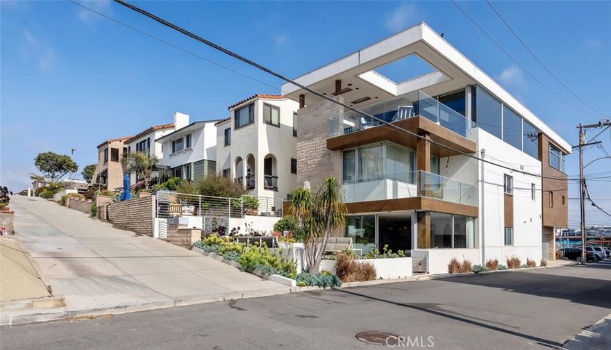 Welcome to one of the most exceptional rental opportunities in Manhattan Beach—a striking, modern retreat offering over 4,600 sq ft of refined coastal living in the highly sought-after Sand Section. Designed by acclaimed architect John Starr and built by Mike Davis in 2015, this 5-bedroom, 4.5-bath residence blends sleek contemporary design with effortless beachside elegance.
Set on a prominent corner walk street, this home boasts breathtaking, unobstructed ocean views stretching from Palos Verdes to Malibu, showcased through expansive floor-to-ceiling glass. The open-concept design emphasizes seamless indoor-outdoor living, with Fleetwood sliding doors, a tiered patio perfect for entertaining, and a signature all-glass elevator that serves as a dramatic centerpiece.
The lower level is designed for both relaxation and entertainment, featuring a state-of-the-art media room, fully equipped bar, and a flexible exercise or dance studio. Offered fully furnished with sophisticated Restoration Hardware pieces throughout, the home exudes style and comfort in every room. Every detail—from designer lighting to premium finishes—has been curated for luxury and ease.
Ideally located just steps from the sand, the Strand, and the energy of downtown Manhattan Beach, this rare rental offers the sophistication of a Bayview estate with the convenience of true walkability. With world-class views, modern elegance, and an unbeatable location, this is beach living at its absolute best.