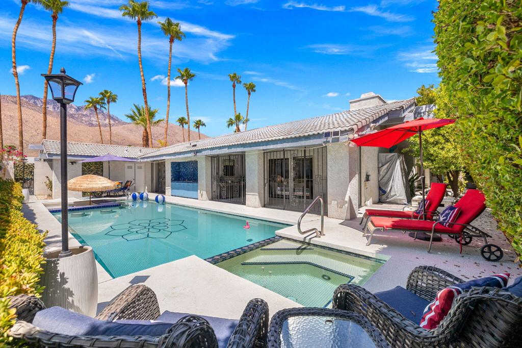 Set in the prestigious Indian Canyons neighborhood of South Palm Springs--one of the most sought-after addresses in the desert. This home embodies the best of Palm Springs living. Situated on fee simple land (you own it), the property welcomes you through double entry doors into soaring vaulted ceilings with exposed beams and an open layout featuring living and dining areas, a fireplace, and a step-down wet bar. The home offers three spacious bedrooms with ensuite baths, including a versatile third bedroom/den with private entry and mountain views. The kitchen is designed for both function and style with granite counters, built-in appliances, a breakfast nook overlooking the mountains, and direct access to the two-car garage. Outdoors, a south-facing backyard ensures sun throughout the day with spectacular views of the San Jacinto Mountains. The resort-style setting includes an oversized pool with inlaid tile, spa, swim-up bar w seats, built-in outdoor kitchen, and mature citrus trees.