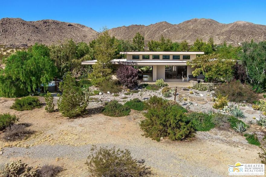 Welcome to Desert Horizon House in Joshua Tree.  This home of newer construction is strategically positioned on an expansive lot, offering breathtaking, unobstructed views of gorgeous desert landscape, nearby hills, and distant mountains.   Both the sunrise and sunset are magnificent here.  Crafted by a renowned landscape architect, the property boasts a meticulously designed environment featuring a harmonious blend of trees, vibrant plantings, and majestic boulders that accentuate the panoramic beauty of the desert.  Enclosed by a fully fenced perimeter, a bespoke custom metal gate welcomes you to this unique sanctuary in the high desert.   As you step onto the property, you'll discover a haven for avian enthusiasts, complemented by enchanting and spectacular plantings that envelope the property.   The residence itself is a testament to simplicity and spaciousness, featuring soaring cathedral ceilings that evoke the ambiance of a pavilion nestled within an exquisite garden.  The seamless integration of glass sliders on either side of the house allows for a transformative experience, where the boundaries between indoor and outdoor living vanish.  Let the gentle desert breeze flow through the open space, creating an atmosphere of tranquility and relaxation. This home is not just a residence; it's an invitation to immerse yourself in a special kind of peace that defines high desert living. Welcome to your oasis of serenity in Joshua Tree.  Offered furnished for your immediate enjoyment.