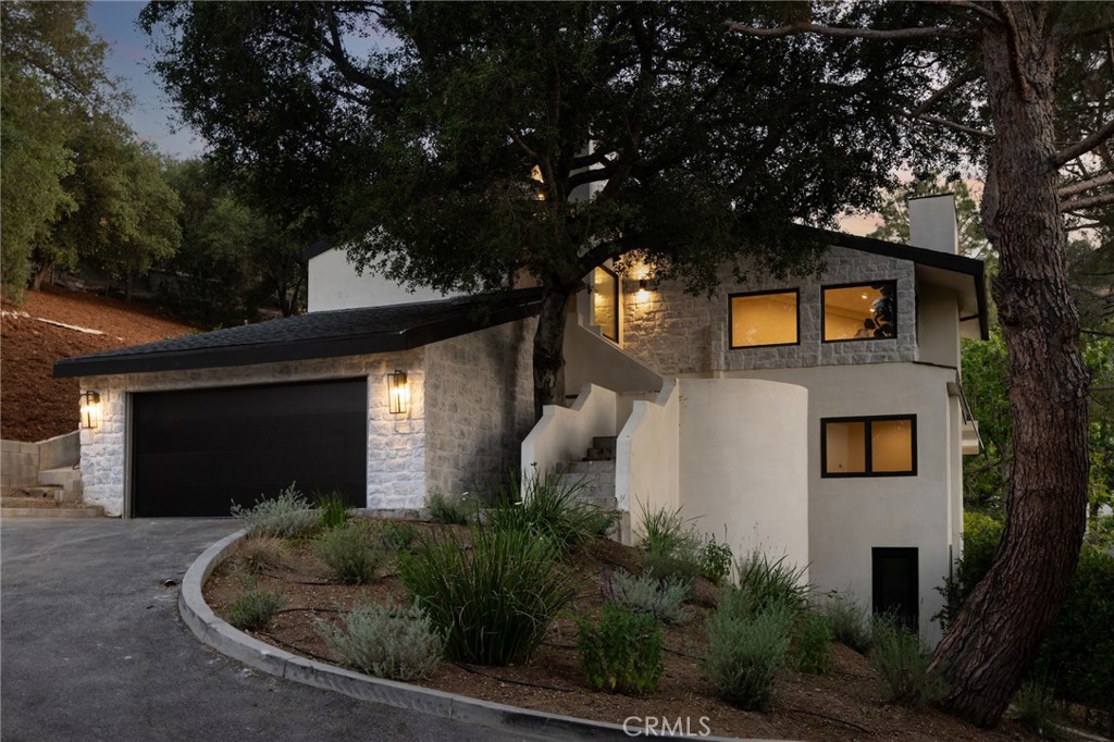 Privately gated and tucked away at the end of a quiet cul-de-sac in Studio City’s desirable “Silver Triangle,” this beautifully remodeled two-story home offers the perfect blend of style, comfort, and privacy. Surrounded by mature trees and lush landscaping, the 5-bedroom, 5-bathroom residence feels like a peaceful retreat while still being just moments from Ventura Boulevard’s shops, restaurants, and studios.
Completely remodeled down to the studs, the home has been thoughtfully transformed with wide-plank wood flooring, custom cabinetry, and high-end finishes throughout. Bright, open spaces with vaulted ceilings and large windows fill the home with natural light and a welcoming atmosphere.
The living room features dramatic ceiling heights and an airy layout, creating an ideal space to relax or entertain. The chef’s kitchen is equipped with top-of-the-line appliances and an oversized center island, offering generous counter space and storage. It flows seamlessly into the family room with a fireplace and sliding doors that open to a quiet deck—perfect for indoor-outdoor living.
All five bedrooms include en-suite bathrooms, offering comfort and privacy for every resident or guest. The spacious primary suite serves as a private retreat, complete with luxury finishes and spa-like amenities.
A versatile bonus space adds even more value—ideal for use as a home office, gym, creative studio, or future ADU, giving flexibility for evolving needs.