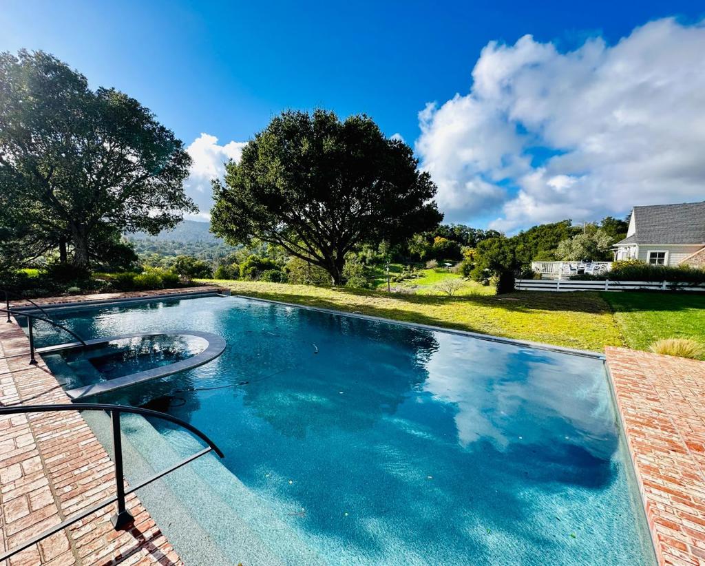 Enjoy sweeping Western Hill VIEWS from this gorgeous turnkey Cape Cod style home in the Woodside Elementary School district ! Resort like living awaits with a sparkling infinity POOL & spa, picturesque pinot noir VINEYARD & bucolic horse pasture. Entertain in the gorgeous POOL CABANA w/ kitchenette, full bathroom & sauna, surrounded by a beautiful huge brick patio. The home features elegant & spacious separate Living and Dining rooms, gourmet Kitchen with vaulted ceiling adjacent to cozy Fam Rm --all with outstanding VIEWS! Large separate office. Luxurious, MAIN level primary suite with gorgeous white marble bathroom, huge walk-in closet and more views! Rich hardwood, French doors, Carrera marble, custom cabinetry throughout. 5 CAR GARAGE--2 car attached +3 car NEW detached garage. HUGE deck off all main rooms overlooks the Western Hills. This is an exceptional home and property !