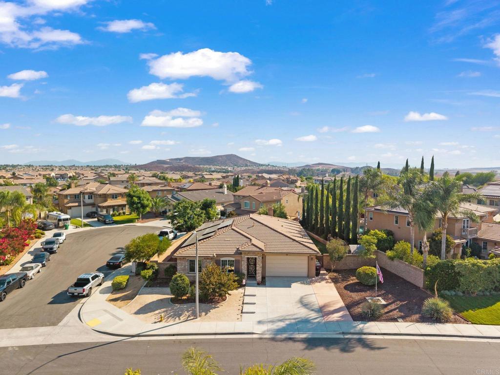 This highly sought-after single-story home sits on a spacious 10,000+ square foot corner lot with drought-tolerant landscaping, a welcoming front walkway, and no HOA—offering the potential for RV parking. With over 2,800 square feet of living space, the home features five bedrooms plus an additional office or study that could serve as a sixth bedroom (no closet), along with three full bathrooms. The entry is highlighted by soaring 11-foot ceilings, creating a grand and open feel. At the heart of the home, the gourmet kitchen showcases a large island, abundant white cabinetry with pantry, stainless steel appliances, granite countertops, and a custom subway tile backsplash. The kitchen opens seamlessly to the expansive great room, pre-wired for surround sound, as well as the formal dining area. The private owner’s suite is situated on its own side of the home and offers a spa-like bathroom with an oversized walk-in shower, separate soaking tub, and generous walk-in closet. Additional features include a dedicated laundry room with sink and window, whole-house QuietCool system, tinted windows, a decorative security screen at the entry, pre-wiring for an alarm system, and ceiling fans throughout. The exterior offers multiple spaces for outdoor living, including a covered patio, gazebo, manicured landscaping, tool shed, motion-activated security lighting, and electrical wiring for future landscape lighting. Located in the award-winning Temecula school district and close to parks and shopping, this home is a must-see.