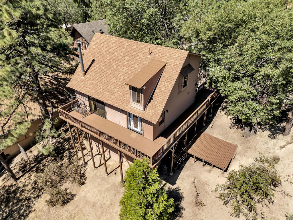 Welcome home to your mid century, blank canvas, just waiting to be a show stopper! Enjoy breathtaking views of LIly Rock and the Idyllwild valley from this spacious four bedroom home with an office and versatile floor plan. Step out onto brand-new redwood decking and take in breathtaking, unobstructed views of iconic Lily Rock and Tahquitz Peak. The entry offers a large open kitchen and dining area that wrap around an open mid cetury style staircase, into the oversized Living room with vaulted ceiling and woodburning stove. There is a bedroom and 3/4 bath on that main level for convenience and for those wanting to age in place. Upstairs are two additional bedrooms with a full bath and views from every window. Downstairs you'll find a billiard room, two additional bedrooms - one could be an office, a 3/4 bath, laundry, deck and porch leading out to the yard. The property sits on almost 1/2 acre with over 2,300 sq.ft. inside and offers a circle drive for ease in the winter months. All decking has been refurbished so bring the family or retreat group or separate the downstairs into its own domain - making an income producing unit with seperate entrance and deck. Versatility makes this one amazing!