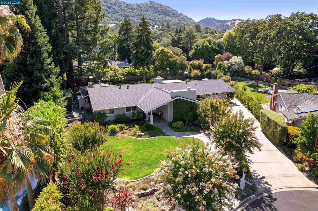 Nestled at the end of a peaceful court in highly sought-after Westside Danville, this charming single story home sits on a flat and usable 0.44 acre lot. Offering an ideal blend of privacy, natural beauty, and convenience, this home is just a short stroll to the quaint downtown with boutique shops, restaurants and amenities. The park-like backyard is truly a retreat, featuring lush, mature flowering landscaping, serene views of the Las Trampas Foothills, and a swimming pool thoughtfully positioned toward the rear of the property, leaving an expansive lawn and multiple entertaining areas. Enjoy gatherings on the spacious stone patio, or beneath the shaded pergola. Meandering garden pathways add a layer of charm to the tranquil setting. The curb appeal evokes a Napa-style retreat, with a long driveway that sets the home back from the court offering both privacy and presence. A charming front porch welcomes you, framed by an ivy-covered wall and a gated front courtyard patio. Inside the home offers a warm and inviting layout with tastefully updated bathrooms and a beautifully appointed kitchen. The LR features a volume wood ceiling while an office nook provides a functional and cozy workspace. Close proximity to the Iron Horse Trail, award-winning schools and Downtown Danville!