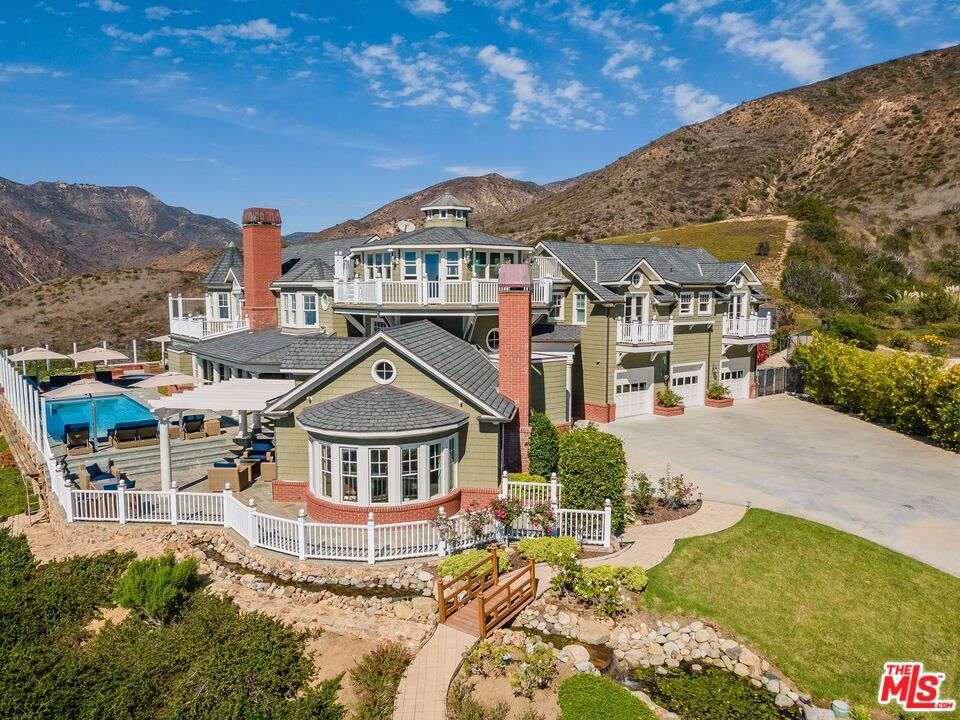 Breathtaking ocean and mountain views from this gorgeous 4-story Cape Cod-style estate is the ultimate in luxury & understated elegance. Perfect for grand entertaining & comfortable family living. The 5 bdrm/6 ba gated home w/hardwood floors and panoramic mountain and ocean views throughout, offers a stunning entry w/sweeping staircase; formal living room w/bay windows, fireplace & glass doors that open to a resort-style outdoor entertaining area with pool/spa, fire pit; formal dining room w/coffered wood ceilings; gourmet kitchen w/wood Island, Marble counter tops & high-end appliances; large family/media room w/fireplace; romantic owner's suite w/fireplace, 2-large closets & spa bath; Jack & Jill suite w/sitting & office area; sweeping ocean view 4th-floor rotunda/office; 3-car garage plus sauna & additional bonus rooms. Separate and detached Large Guest House w/ wrap around decks and ocean views. Expansive grounds w/ a charming waterfall. Privacy abounds. Includes secondary solar panel power system. Available Short or Long term