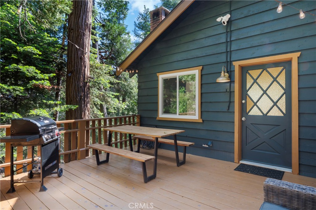 Nestled in the serene beauty of Lake Arrowhead, this enchanting 2 bedroom, 2 bath upgraded home invites you to unwind, reconnect, and savor the best of alpine living. Just minutes from the heart of Lake Arrowhead Village and the whimsical charm of Sky Park at Santa’s Village, this home blends mountain elegance with everyday comfort. Step inside to find a light-filled interior with rustic wood beam ceilings, an open-concept living area, and a stone-framed fireplace that sets the tone for cozy nights in. The fully appointed kitchen features modern appliances, updated cabinetry, and a breakfast bar perfect for morning coffee or evening wine. Both bedrooms offer peaceful forest views and thoughtful design, while the beautifully updated bathrooms boasts a soaking tub and shower with artisan tile work, creating a luxury experience. Outdoors offers a spacious forest view deck opening up to treetop vistas and breathtaking sunsets ideal for entertaining, grilling, or simply soaking in mother nature. Towering pines surround the property, offering privacy and a sense of seclusion, while still being close to shops, dining, and year round recreation. Whether you’re hosting friends around the fireplace, sipping cider beneath the stars, or enjoying morning hikes by the lake, this home is the perfect escape crafted for those who crave nature, comfort, and connection.
