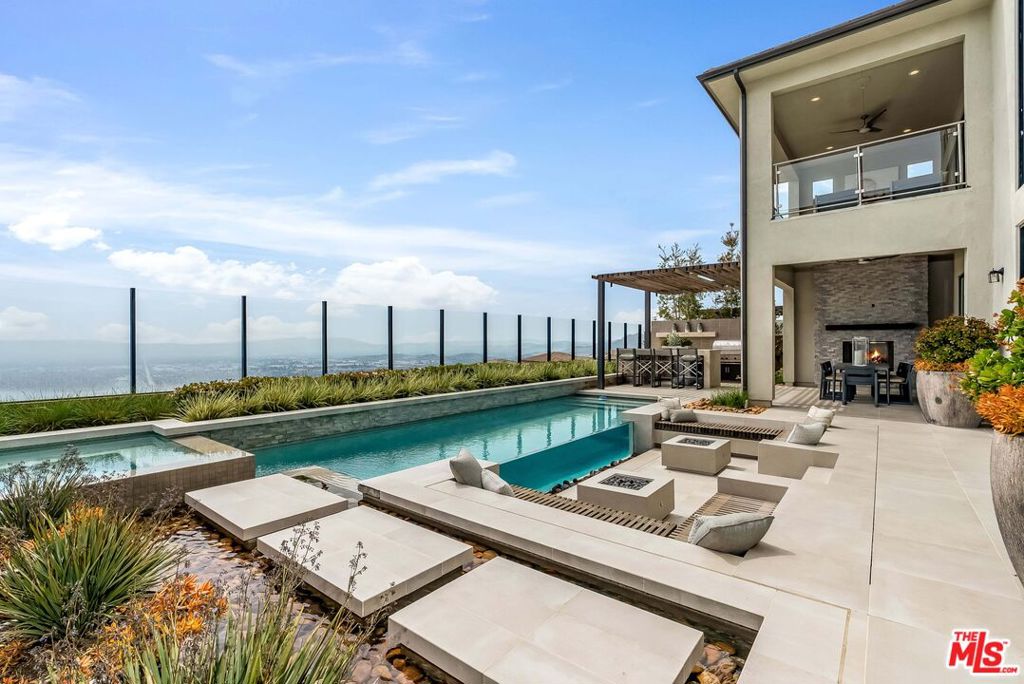Welcome to unparalleled elegance in the prestigious, guard-gated community of Westcliffe at Porter Ranch Summit Collection. This never-before-lived-in Santi Elite MODEL HOME is a one-of-a-kind masterpiece, meticulously curated by Toll Brothers' award-winning interior design team with sophisticated finishes and designer details throughout. Perched high on a scenic hillside, the home offers breathtaking panoramic views of city lights stretching across the valley to the south an extraordinary backdrop for luxurious daily living. Step through the inviting covered entry into a grand two-story foyer, which flows seamlessly into a stunning great room, an expansive casual dining area, and a luxury outdoor living space perfect for entertaining or relaxing in style. The gourmet kitchen is a chef's dream, featuring a large center island with breakfast bar, ample cabinetry, extensive counter space, and a spacious walk-in pantry. This highly upgraded residence features 5 spacious bedrooms, each with its own private en-suite bathroom, including a convenient first-floor guest suite perfect for multigenerational living or accommodating visitors in comfort. A dedicated office/flex space offers versatility for remote work, a study zone, or a creative studio. On the third floor, an expansive media/bonus room includes a powder room and a covered deck an ideal setting for a home theater, lounge, or private escape. The luxurious primary suite is a true sanctuary, highlighted by a massive walk-in closet and a spa-inspired bathroom with dual vanities, a deep soaking tub, a luxe walk-in shower with seating, and a private water closet. Upstairs, a generous loft connects the secondary bedrooms, all offering ample closet space and private en-suite baths, ensuring comfort and privacy for every member of the household. Additional features include a stylish main-level powder room, a centrally located laundry room, and thoughtfully designed built-in storage throughout the home. Ideally located just minutes from the highly rated K-8 Porter Ranch Community School and the prestigious Sierra Canyon School, this extraordinary residence offers a rare blend of comfort, convenience, and sophistication. This is the final opportunity to own this exclusive designer model home. Luxury, elevated your dream lifestyle awaits.