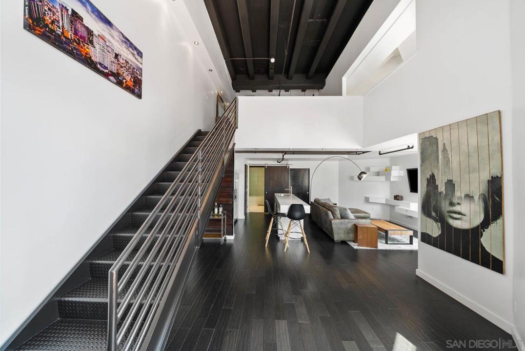 Rare & stylish bachelor(ette) loft featuring striking 20-foot ceilings & an outdoor patio. Don't be discouraged by monthly HOA. The current owner is paying only $2,200 ANNUALLY* in property taxes because of Mills Act Historic designation. Private entrance accessible from 1st floor of building, NO elevator needed! Step through elegant French doors into an expansive, sunlit open space with soaring ceilings, exposed beams, and an urban NYC loft ambiance ideal for art displays. The main level offers beautiful natural wood floors, a modern kitchen with island, spacious living area, full guest bath, and walk-in storage. Upstairs, the loft includes a roomy bedroom, dedicated office area, walk-in closet, and second full bath. Outside, relax on your private patio nestled among jacarandas with views of the city skyline. Perched 175 feet above sea level, the iconic El Cortez is a San Diego Historical Landmark listed on the National Register of Historic Places. Originally built in 1927, it has hosted notable guests like Eisenhower and Elvis Presley. Set in tranquil Cortez Hill, you're close to Petco Park, Gaslamp, Little Italy, and Balboa Park. Amenities include parking, fitness center, pool, and EV chargers. Visit this exceptional home today—Carpe Diem! *Mills Act subject to annual assessment and extension every 5 years. Buyer to satisfy themselves with Mills Act terms.