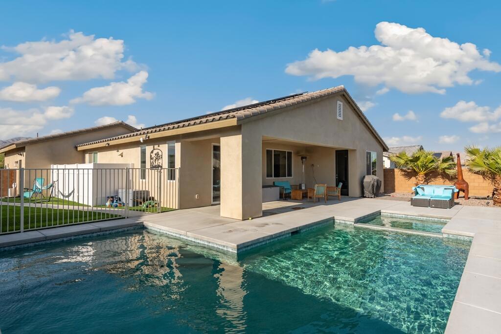 Gorgeous FIVE bedroom, THREE bathroom, Pool Home, that was recently built in 2021, and located in the desirable and gated Agua Dulce community is ready to be made yours! This home offers great curb appeal with mountain views, Owned Solar Panels, a gated front entry, and attached 2-Car Garage with an included Electric ChargePoint Brand, Car Charger! The interior features an open floor plan with high ceilings, recessed lights, a custom paint scheme and vinyl plank flooring throughout. The living area includes a ceiling fan and a large picture window with views of the backyard. The dining area offers a modern chandelier and sliding glass door to the patio and the gorgeous kitchen has quartz counters with breakfast bar seating, pendant lights over the breakfast bar area, tile backsplash, stainless steel appliances, and a pantry. The large primary suite also offers a private door to the backyard and a spa-like ensuite with full-size walk-in shower, dual sink vanity, and a walk-in closet. The 4 secondary bedrooms are on the opposite side of the home off of the entry hall and none of the bedrooms have a shared wall. There are 2 more bathrooms for the secondary bedrooms and guests to share and a laundry room with additional storage cabinets, quartz counter, and a sink. Enjoy the private backyard with built-in covered patio and wrap around pool and spa! Sellers spent $80,000 on the new pool and spa as well as on landscaping and hardscaping! This is the perfect space for relaxing and entertaining! There is also a generously sized, gated, side yard with turf grass and concrete pathway - great for a dog run. The community also offers a large pool and spa, and offers low HOA fees. This home is conveniently located not far from schools, shopping, dining, and more! Schedule your tour today!