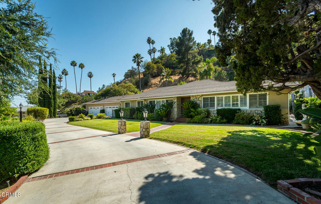 Set behind a secure gate in the tranquil Glendale hills, this upgraded single-level ranch-style residence offers privacy, space, and comfort in a beautifully landscaped setting. A spacious motor court, classic stone-accented exterior, and inviting front entry create timeless curb appeal.A large beveled glass front door opens to the formal entry. To the right, the living room is filled with natural light from front-facing windows and features a marble fireplace. Across the entry, the formal dining room flows into the updated kitchen, complete with quartz countertops, stainless steel appliances including a double convection oven, gas cooktop, range hood, dishwasher, and high-end plumbing fixtures. Both the kitchen and breakfast nook enjoy peaceful views of the motor court.The adjacent family room offers vaulted ceilings and French doors that open to a spacious covered patio--perfect for dining and entertaining. Just beyond, a gated sparkling pool and spa are surrounded by mature landscaping and a serene hillside backdrop.The bedroom wing is located behind a set of interior doors, offering separation and privacy. To the right is a powder room, followed by the primary suite with generous closet space and an updated en suite 3/4 bath. Further down the hall, the second bedroom includes floor-to-ceiling windows and French doors to the pool. The third bedroom, located on the left side of the hall, adjoins the family room and features French doors leading to the covered patio.A full bathroom is located between the second and third bedrooms and connects to a separate laundry room with exterior patio access.Additional features include LED recessed lighting, crown molding, wood floors throughout, manicured landscaping with citrus trees, and a 4-car garage with built-in cabinetry. A dedicated half bath located off the garage is accessible from the backyard--perfect for poolside use.Located just minutes from Verdugo Park, Oakmont Country Club, Montrose Shopping Park, and with easy access to The Americana at Brand, Glendale Galleria, and freeways to Pasadena, Burbank, and Downtown LA.Don't miss this rare lease opportunity that blends thoughtful updates, classic character, and easy indoor-outdoor living in one of Glendale's most desirable hillside neighborhoods.