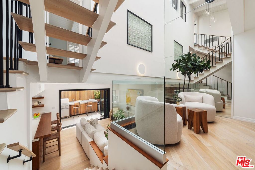 Steps off Montana Ave, this sleek contemporary-transitional home blends modern design with effortless Westside living. Step inside and you're greeted by soaring double-height ceilings, skylights that pour in natural light, and an open-concept layout that feels airy and inviting. The floating staircase, white oak floors, and loft-like vibe set the tone for a stylish yet comfortable space. The living and dining areas, anchored by a cozy working fireplace, flow seamlessly into the family room and chef's kitchen, creating the ultimate setup for entertaining. Accordion glass doors open wide to a private outdoor lounge with a built-in BBQ and bar seating, offering the perfect spot for dinners, weekend gatherings, or simply soaking up the SoCal sunshine. The kitchen itself is a design statement with custom walnut cabinetry, sleek stainless appliances, and a casual eat-in bar that makes cooking and conversation effortless. A powder room on the main level adds everyday convenience. Upstairs, the primary suite is a true retreat with its own balcony, oversized walk-in closet, and a spa-like bath featuring dual vanities, generous storage, and a frameless glass shower. A second upstairs bedroom offers its own en suite bathroom finished with the same high-end details found throughout the home. Additional upstairs space includes a loft area, perfect as a study nook, yoga corner, or reading lounge, which opens to a spacious outdoor patio ideal for your morning coffee ritual. The lower level brings even more versatility with a third bedroom, currently set up as a media room, that can easily be transformed into a guest suite, gym, or creative studio. Completing this offering is a private gated two-car garage with built-in cabinetry for extra storage, in-unit stacked laundry on the main level, and secure gated access to the upper level. Of course, the lifestyle seals the deal, with Santa Monica Beach just minutes away and Montana Avenue's best cafs, shops, and fitness studios only steps from your front door. This home achieves the perfect balance of modern design, functionality, and coastal cool.
