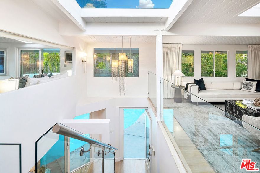 A very special "one of a kind" Mid-Century Oasis, and former of several A-List celebrities. Nestled in a small cul de sac just 2.5 minutes behind The Beverly Hills Hotel, close to Sunset Blvd. This home has an wonderful "vibe", featuring an open floor-plan with excellent indoor/ outdoor flow.  An abundance of natural light fills the home, including 9 sky-lights, and 3 oversized fireplaces. Large sumptuous Primary Suite w/ spa like bathroom, and 2nd bedroom both feature walls of glass which open out to a dramatic 50 ft. Waterfall, pond, lush yard & Fire Pit with hilltop yoga area.  Updated newer Kitchen w/ porcelain counters, custom cabinetry, & top of the line MIELE appliances. Spacious, light-filled living & dining area set atop the trees. Downstairs features a private 3rd bedroom w/ separate gated entrance, perfect for guests, teenager, office or live-in. Media Den with Bar and fantastic sunken "conversation pit", around a fireplace, perfect for movie nights or gatherings. Heated pool with new equipment glows from every room at night. Private and Tranquil with only 2 homes on street and ample parking rarely found in the hills. Private, walled and gated entry, ready to move in! Recent 5 year rental average has been $20,150. This contemporary gem is an incomparable property  and rare offering.