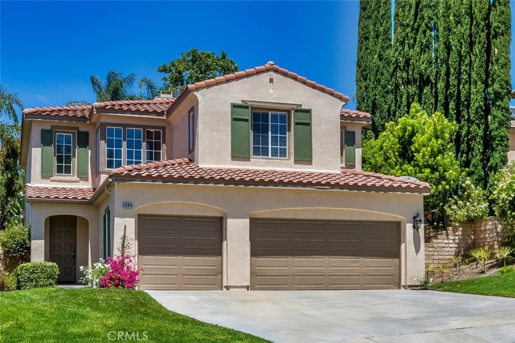 Welcome to this stunning Executive Pool home nestled in the prestigious upper Stevenson Ranch neighborhood, located along a beautiful street lined with oversized cascading lots. From the moment you arrive, the home’s striking curb appeal draws you in, featuring lush landscaping, an expansive driveway, and a sprawling front lawn. Encompassing nearly 3,000 square feet, this home offers five spacious bedrooms, three bathrooms (including one on the main floor), elegant formal living and dining rooms, family room, upstairs laundry room, and an office nook. Step inside to find dramatic vaulted ceilings, newer interior paint, a blend of rich wood and sleek tile flooring, newer carpeting, and an abundance of windows that flood the space with tons of light. The upgraded kitchen features newer shaker cabinetry, granite countertops, stainless steel smart appliances, large center island, a charming breakfast nook, walk-in pantry, and a built-in buffet with matching granite surfaces. The adjacent dining area showcases lovely views of the backyard. The expansive family room offers the perfect space for gatherings, featuring a fireplace and seamless access to your entertainer’s backyard. Upstairs, the generously sized primary suite is a luxurious retreat, with views of the surrounding landscape, dual walk-in closets with custom built-ins, and a spa-like ensuite bath offering dual vanities, upgraded cabinetry, an oversized soaking tub, and a separate walk-in shower. Secondary bedrooms are well-sized, each with ample closet space. The shared hall bath includes dual sinks, upgraded cabinetry and a private shower room. Step outside to your own resort-style backyard on an impressive 10,000+ sq ft lot, complete with a spacious patio, inviting pool and spa accented with gorgeous flagstone, and large side yards ideal for a pet run or additional play area. Multiple relaxing sitting areas provide the perfect setting to unwind on warm California evenings. Additional features include: a solar energy system, Tesla Power Wall, and a three-car garage. Ideally located near Richard Rioux Park, award-winning schools, shopping, restaurants and convenient freeway access.