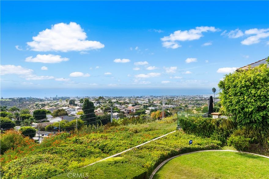 Perched atop the prestigious Spyglass Hill community, this extraordinary residence commands one of the most coveted lots in all of Corona del Mar. With unobstructed, panoramic views stretching across the Pacific Ocean, the sparkling coastline of Corona del Mar, the serene backdrop of Catalina Island, and the famed 8th hole of Pelican Hill Golf Course, the setting is nothing short of breathtaking. By night, the dazzling city lights sparkle below, and with no rooftops in sight, every vista is pure and uninterrupted. Set above a private hillside with no homes directly behind, this estate offers both seclusion and grandeur. The expansive, over 100ft wide backyard is a rare find — an outdoor haven with ample space for entertaining, relaxing, or simply soaking in the endless vistas. Step inside to discover timeless elegance, highlighted by a sweeping spiral staircase and soaring vaulted ceilings that create a dramatic sense of space. The thoughtful floor plan features a main-level bedroom, while upstairs you’ll find four additional bedrooms—three of which boast private balconies to fully embrace the spectacular coastal scenery. The primary suite is a true retreat, complete with its own private office wing, a spacious walk-in closet, a beautifully tiled spa-like bathroom, and a view balcony that showcases the very best of coastal living. Homes of this caliber, in this location, are exceedingly rare to find on the market—offering a once-in-a-lifetime opportunity to own a piece of Spyglass Hill’s finest.